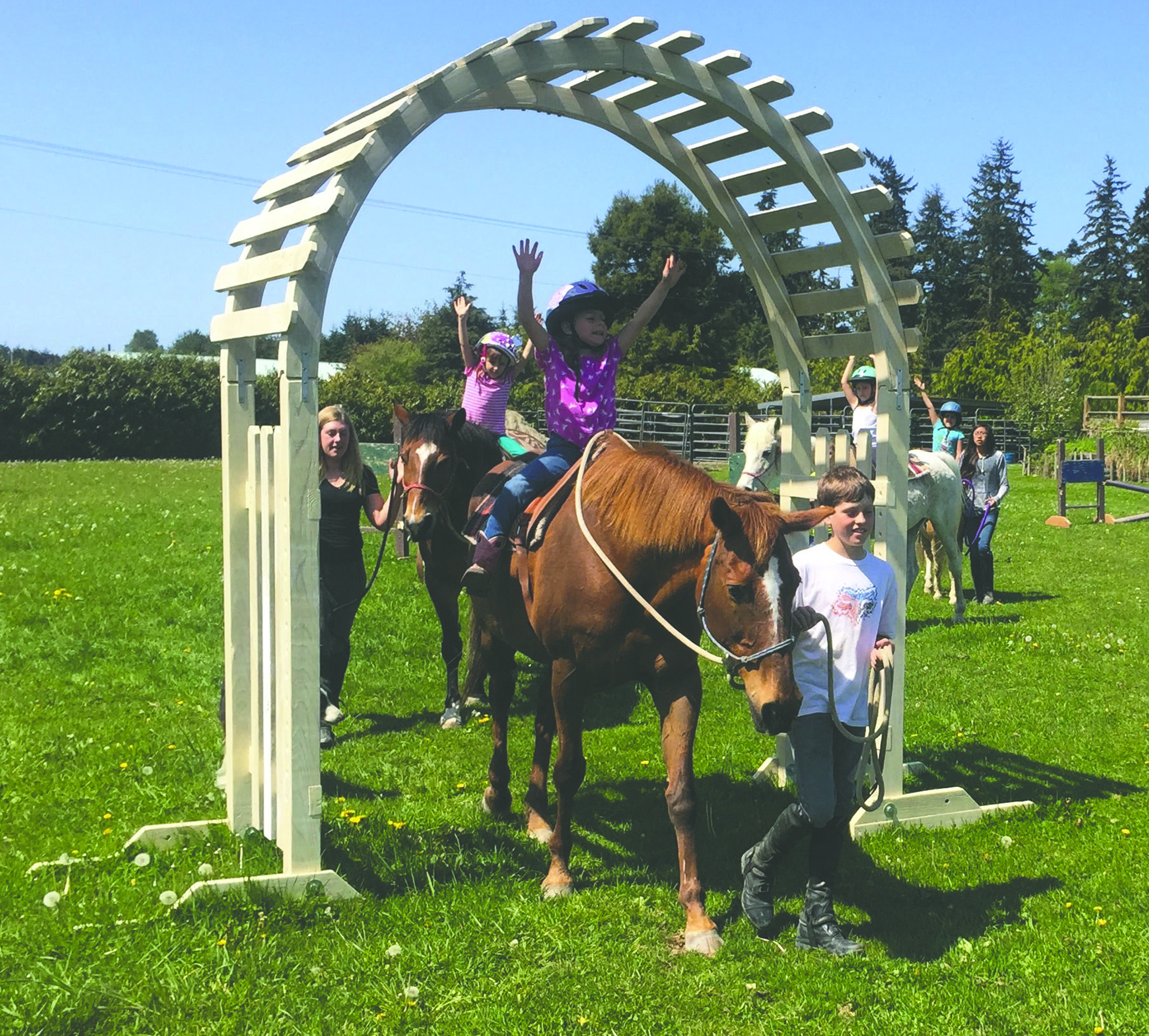 Riders Lily Robertson and Maddie Niemeyer learn confidence and balance as part of a Freedom Farm’s Mini Beats class. They’re accompanied by Hoof Beat Club members Ben Robertson