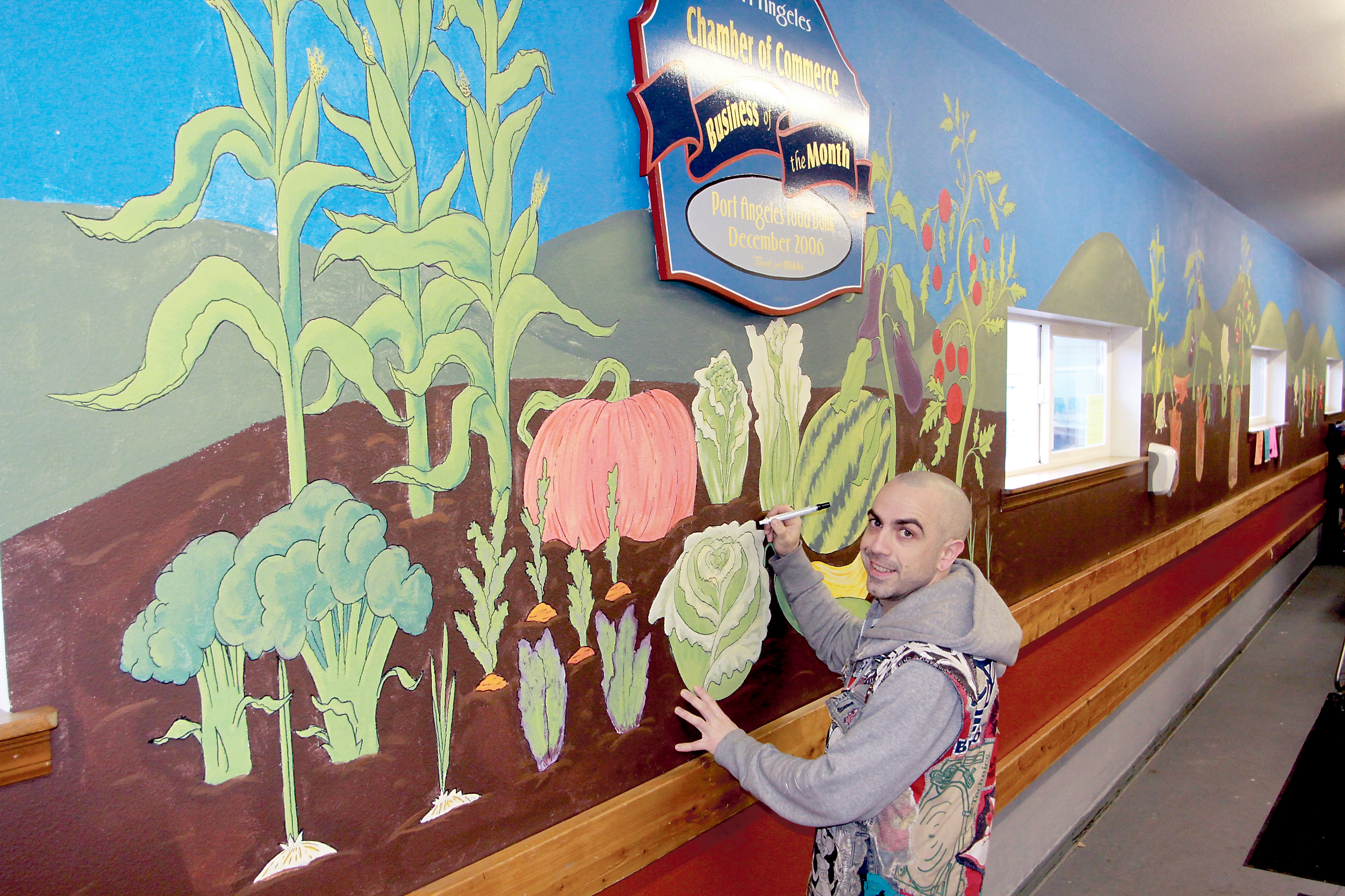 Jimbo Cutler works Tuesday on the new mural inside the Port Angeles Food Bank. — Dave Logan/for Peninsula Daily News ()