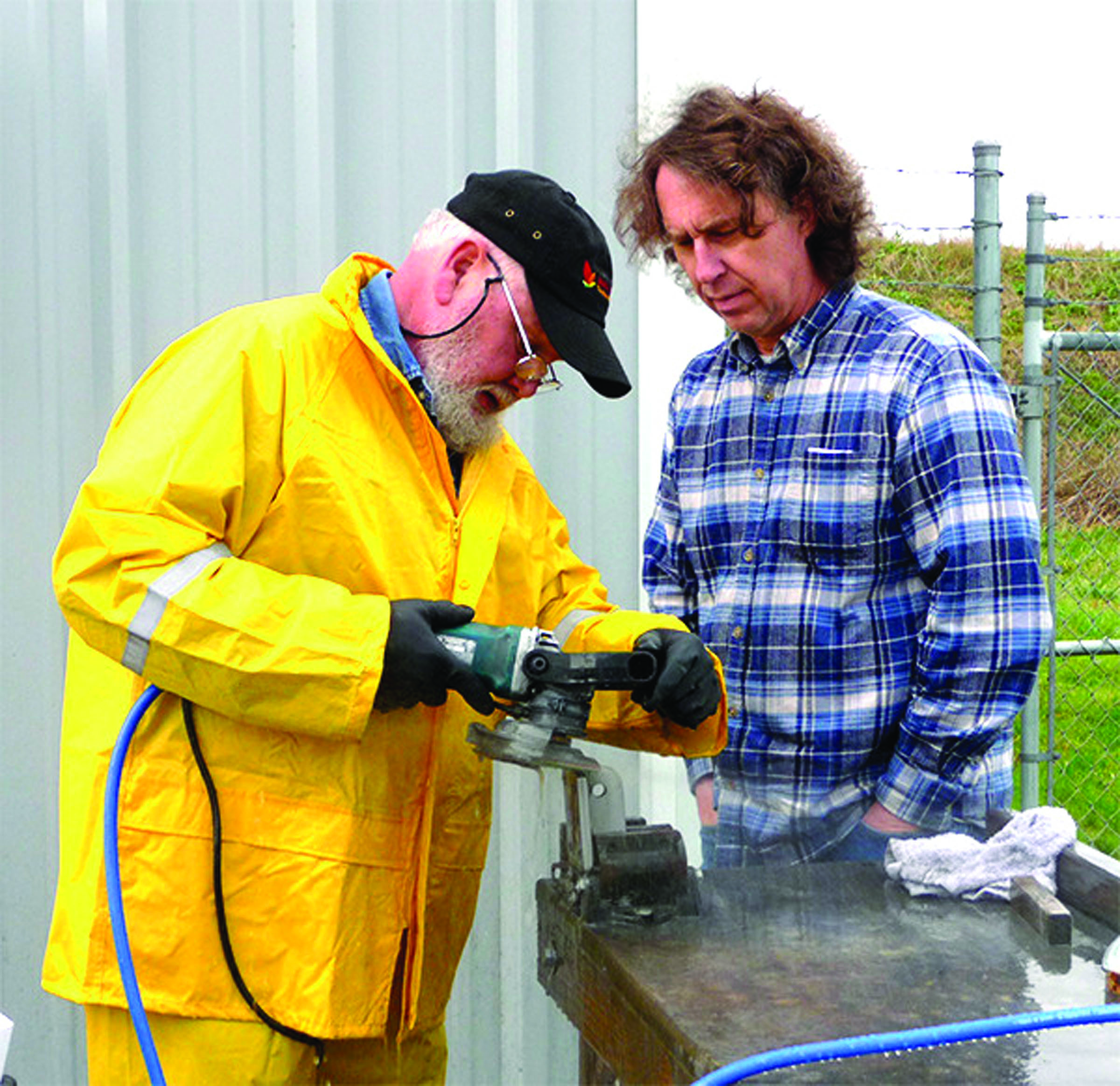 Machinist Bobby Kelly diamond polishes a high strength marine part as Allied Titanium CEO Christopher Greimes watches the process. — Patricia Morrison Coate/Olympic Peninsula News Group ()