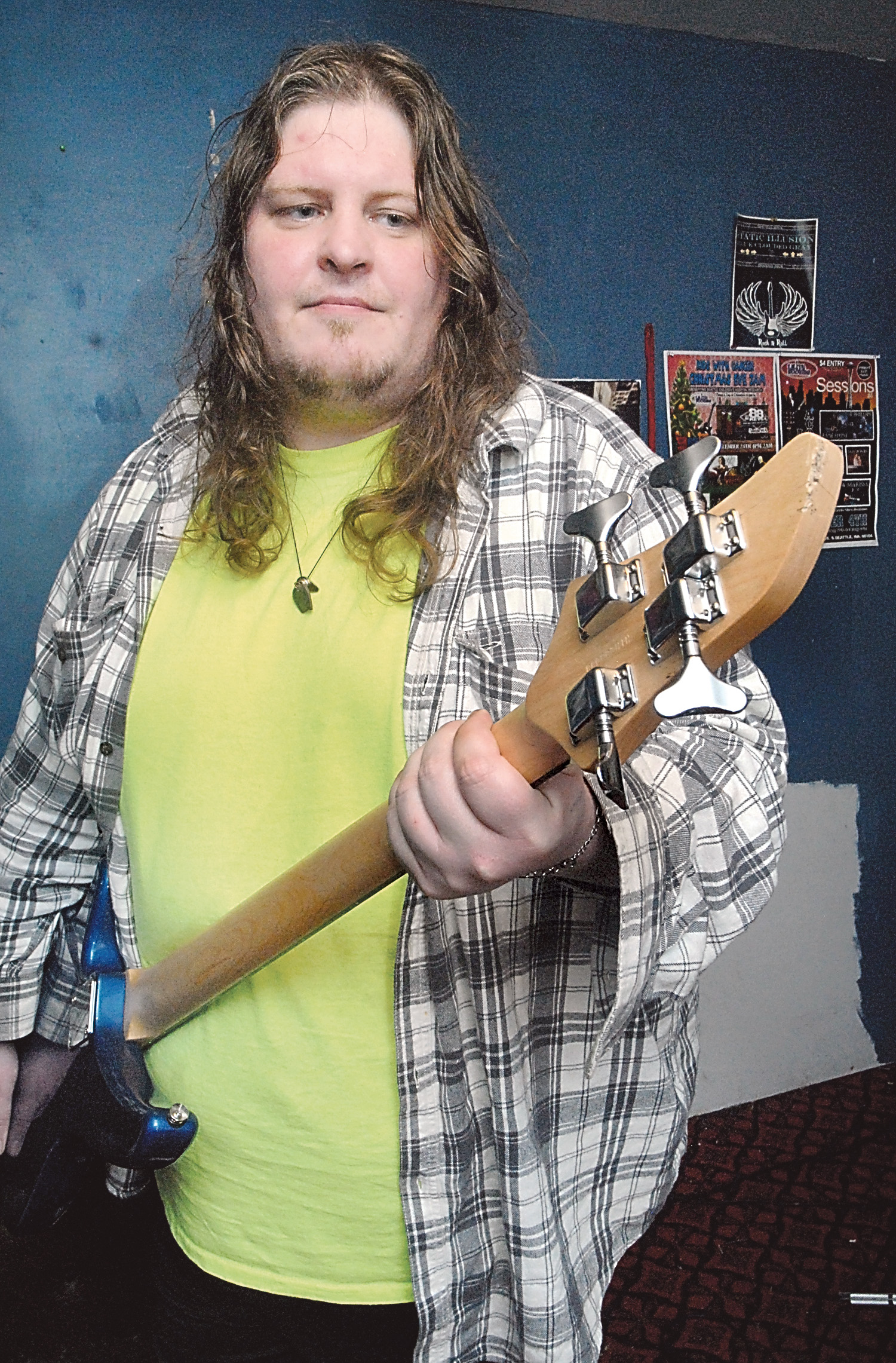 John Kingsley of Port Angeles holds a damaged bass guitar that he said was thrown over a fence by a burglar Friday. —Photo by Keith Thorpe/Peninsula Daily News ()