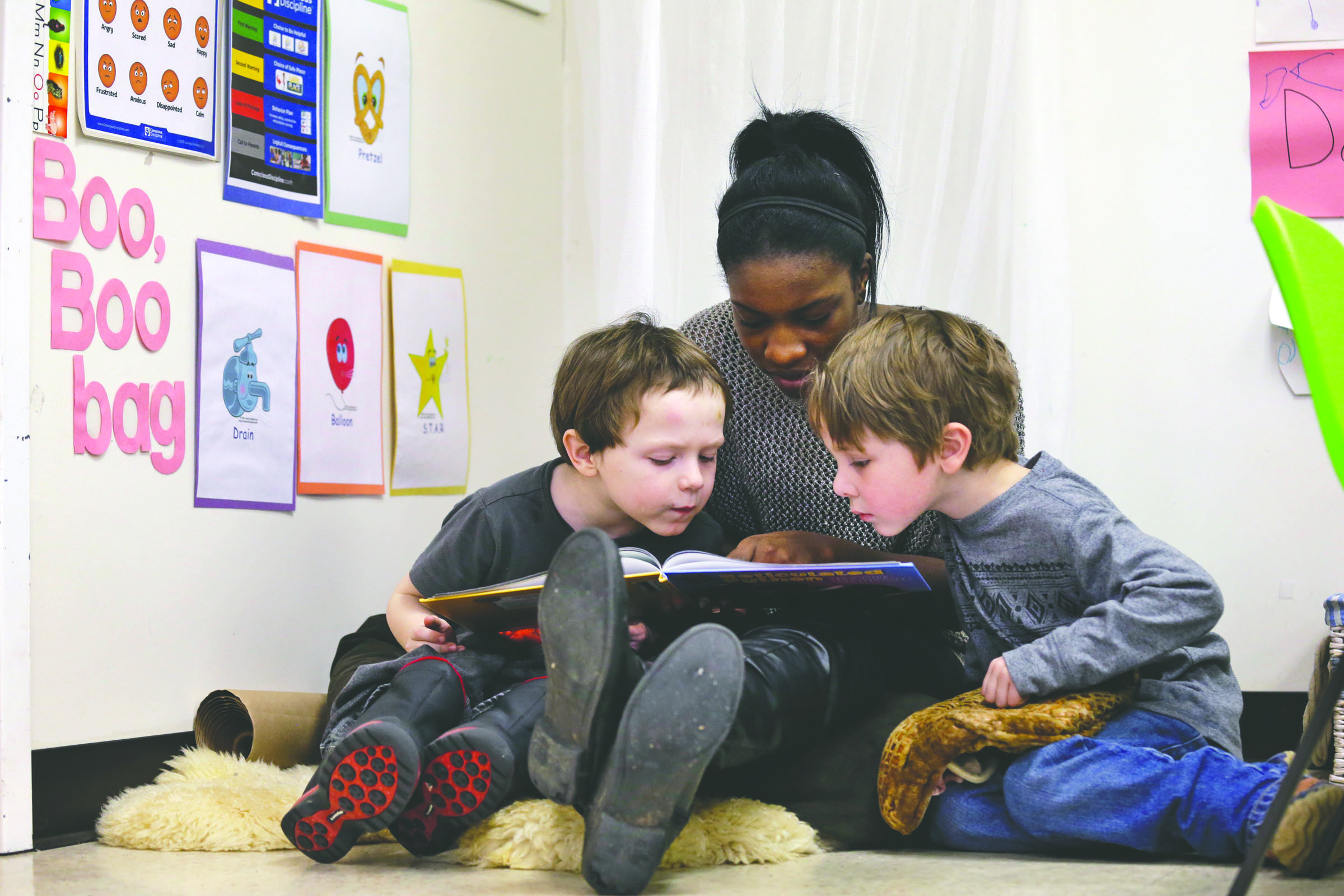 Assistant teacher D'onna Hartman reads to Frederick Frenious