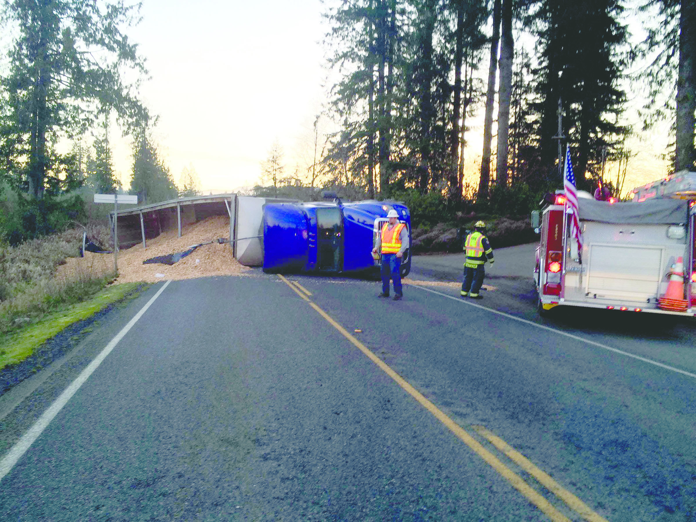 A chip truck driven by a Port Angeles man lies on its side on state Highway 108 near McCleary. The driver