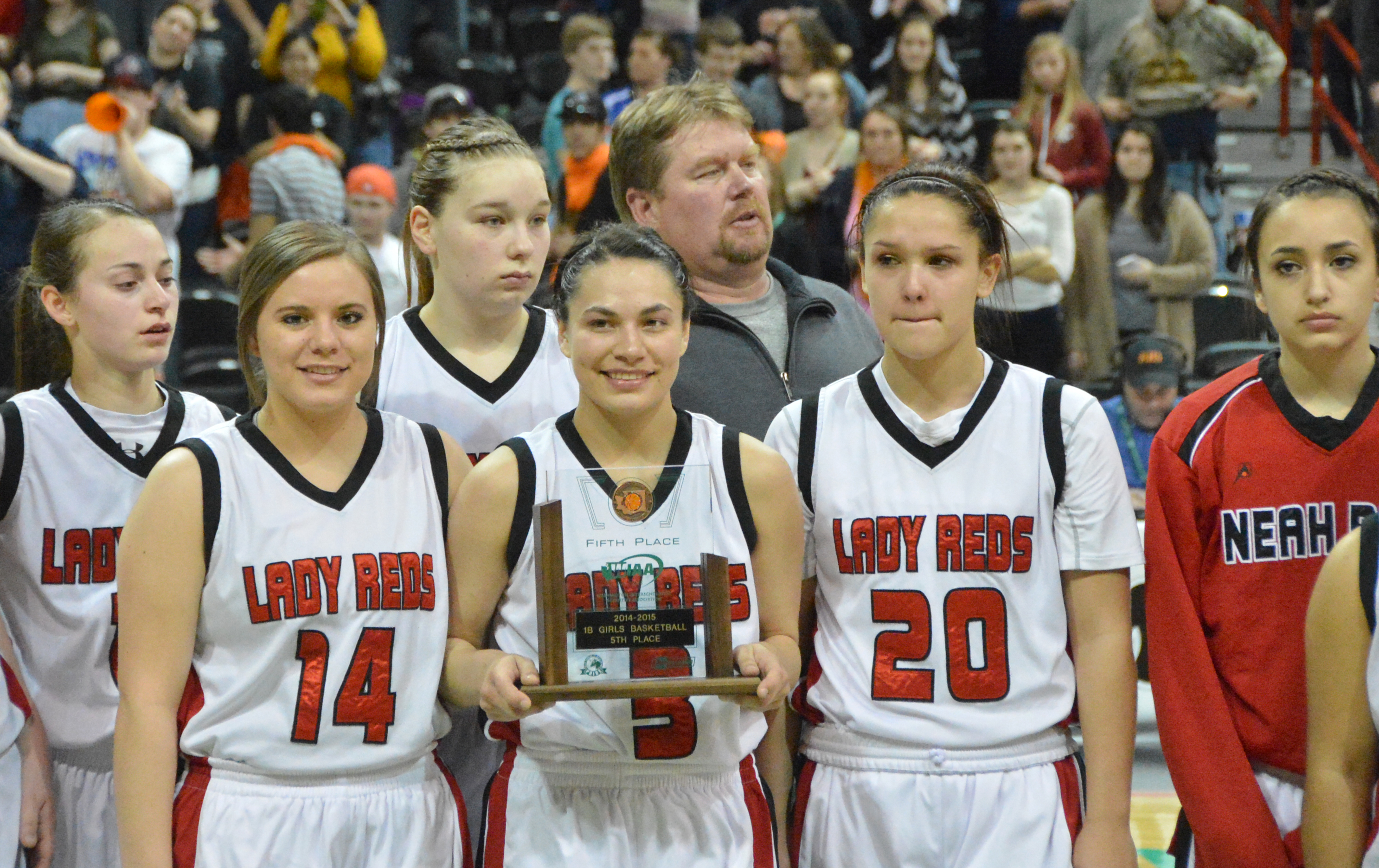Hailey Greene holds the fifth-place trophy won by Neah at the Class 1B state tournament in Spokane. Flanking Hailey Greene are Holly Greene