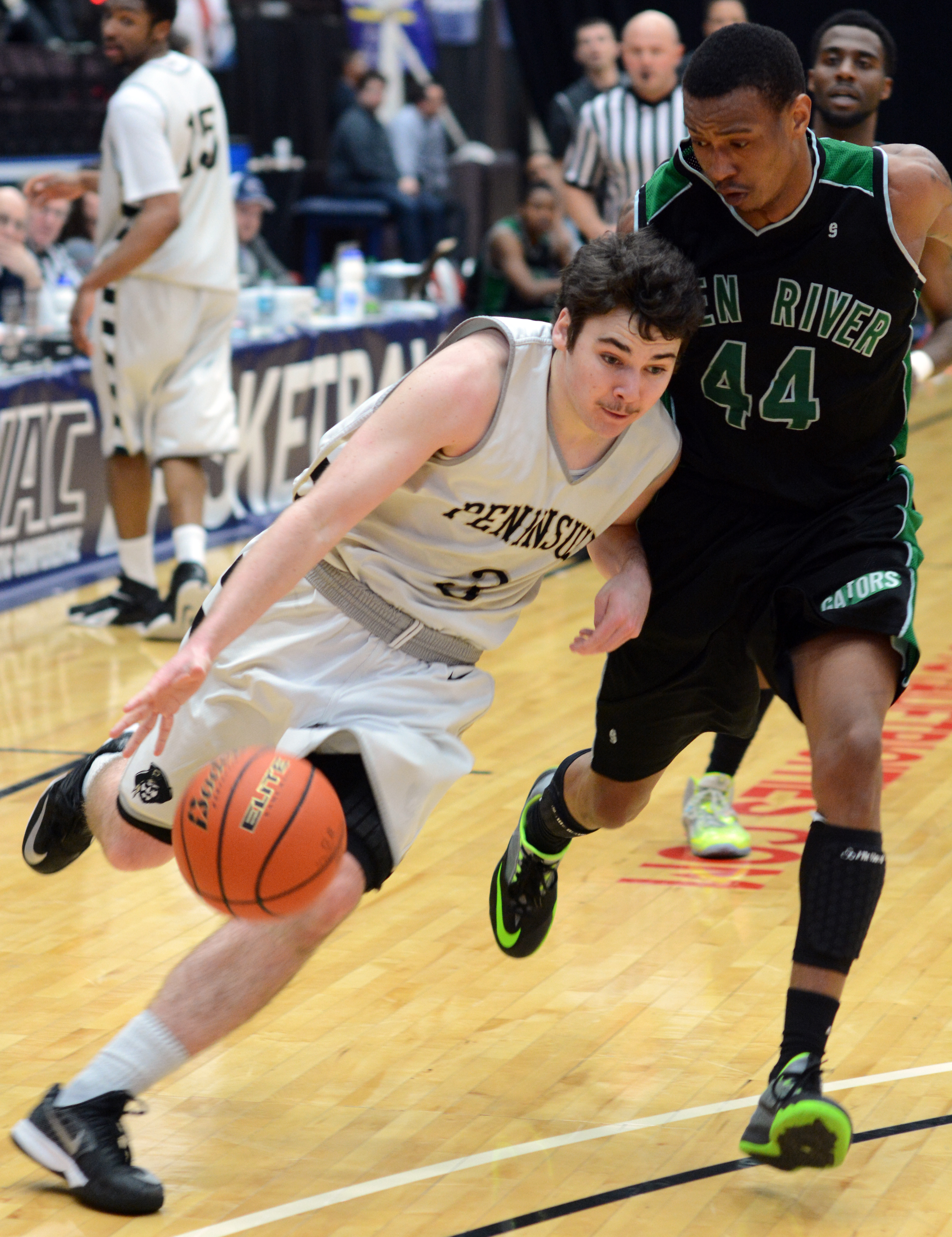 Peninsula's Ryley Callaghan dribbles around Green River's C.M. Garrett at the NWAC tournament. (Rick Ross/Peninsula College)