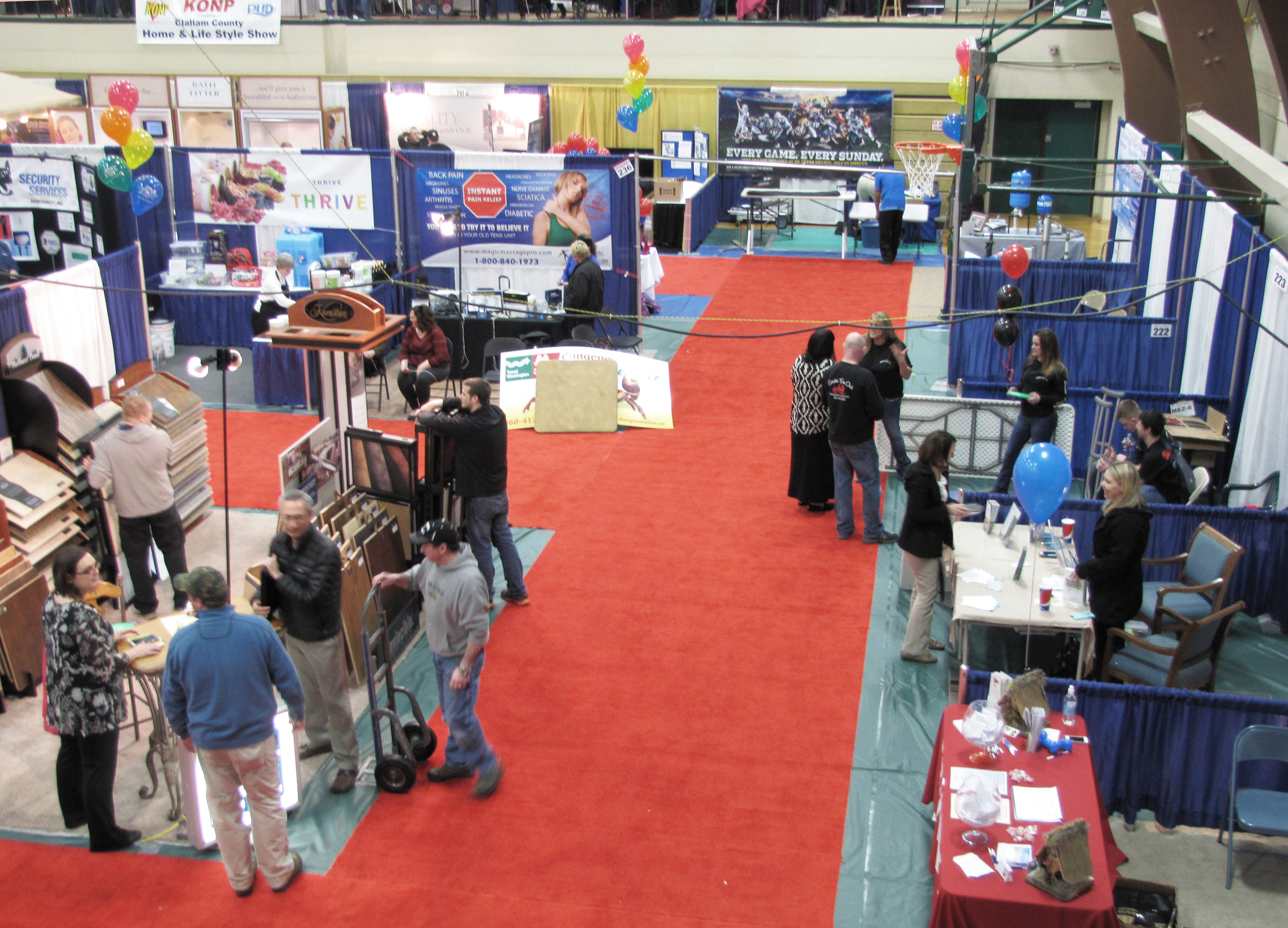A few visitors still chat with business representatives in the waning hours Sunday of the 2015 Clallam County Home and Lifestyle Show. (Arwyn Rice/Peninsula Daily News)