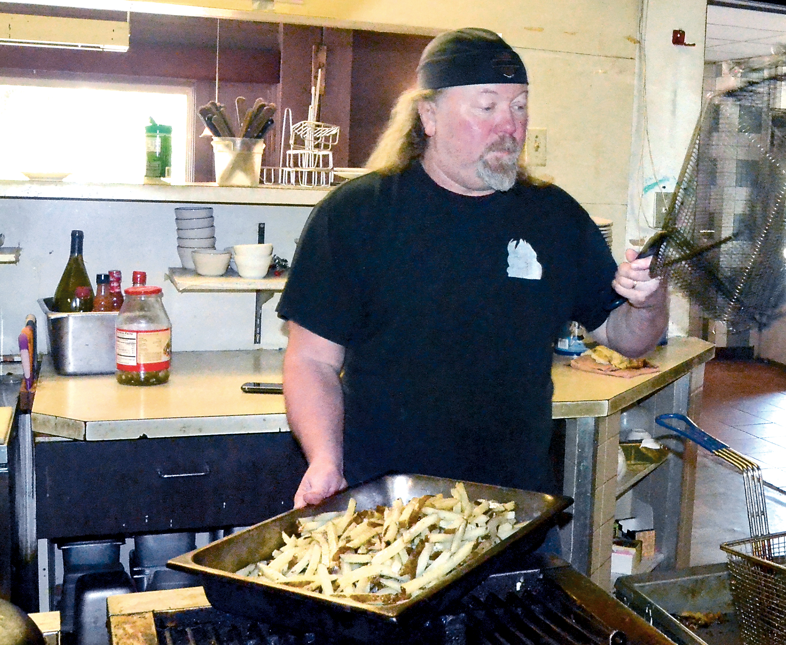 Zoog's Caveman Cookin' Restaurant & Cave Lounge owner Bret “Zoog” Forsberg prepares for the lunch rush Wednesday. (Charlie Bermant/Peninsula Daily News)