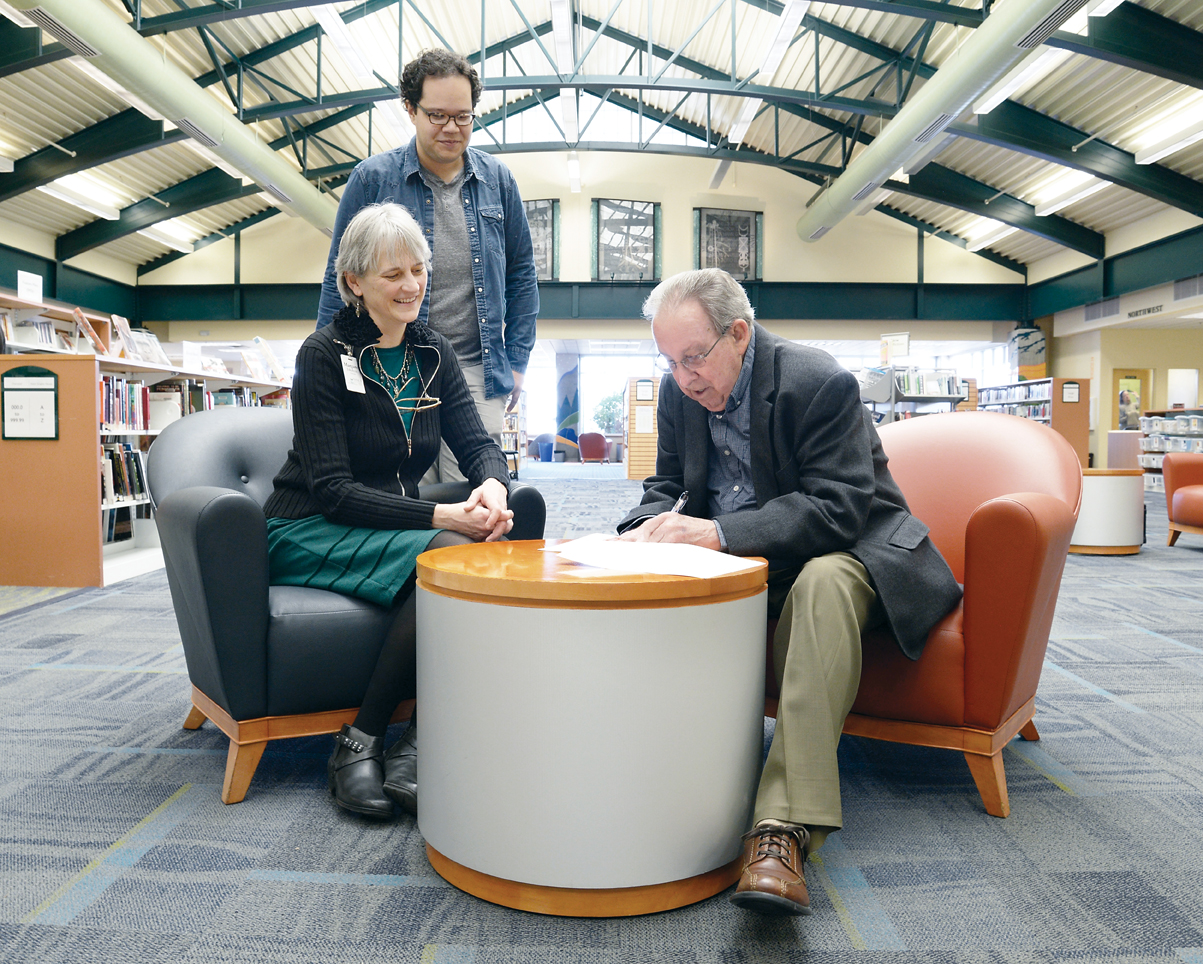 Port Angeles Mayor Patrick Downie signs the deed conveying the Port Angeles Library to the North Olympic Library System on Feb. 25. Observing are Library Director Margaret Jakubcin and Port Angeles Main Library Manager Noah Glaude. — Garrett Fevinger/North Olympic Library System ()