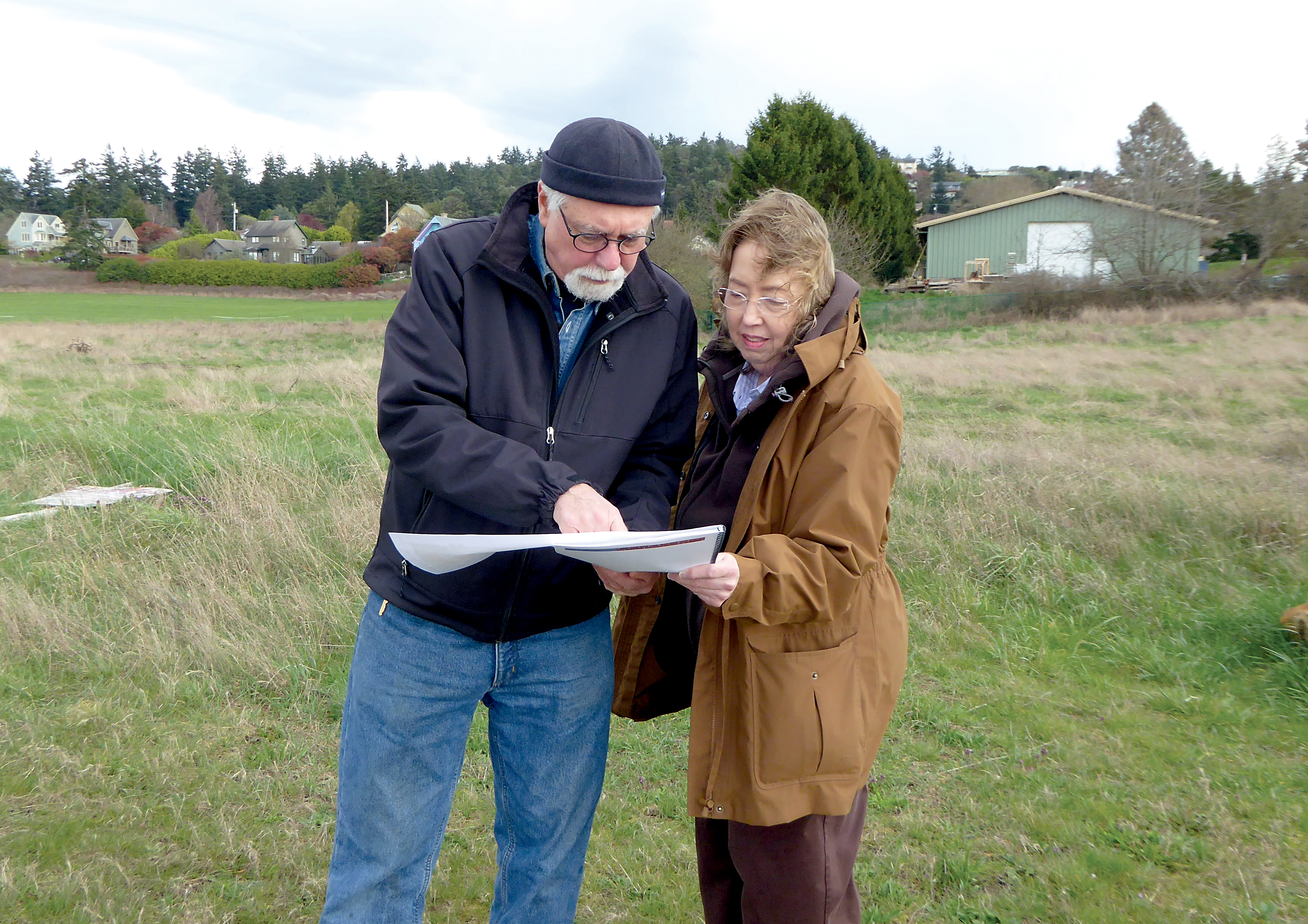 Spokesman Dennis Daneau shows Kay Harper the plans for the new Quimper Village senior co-housing development