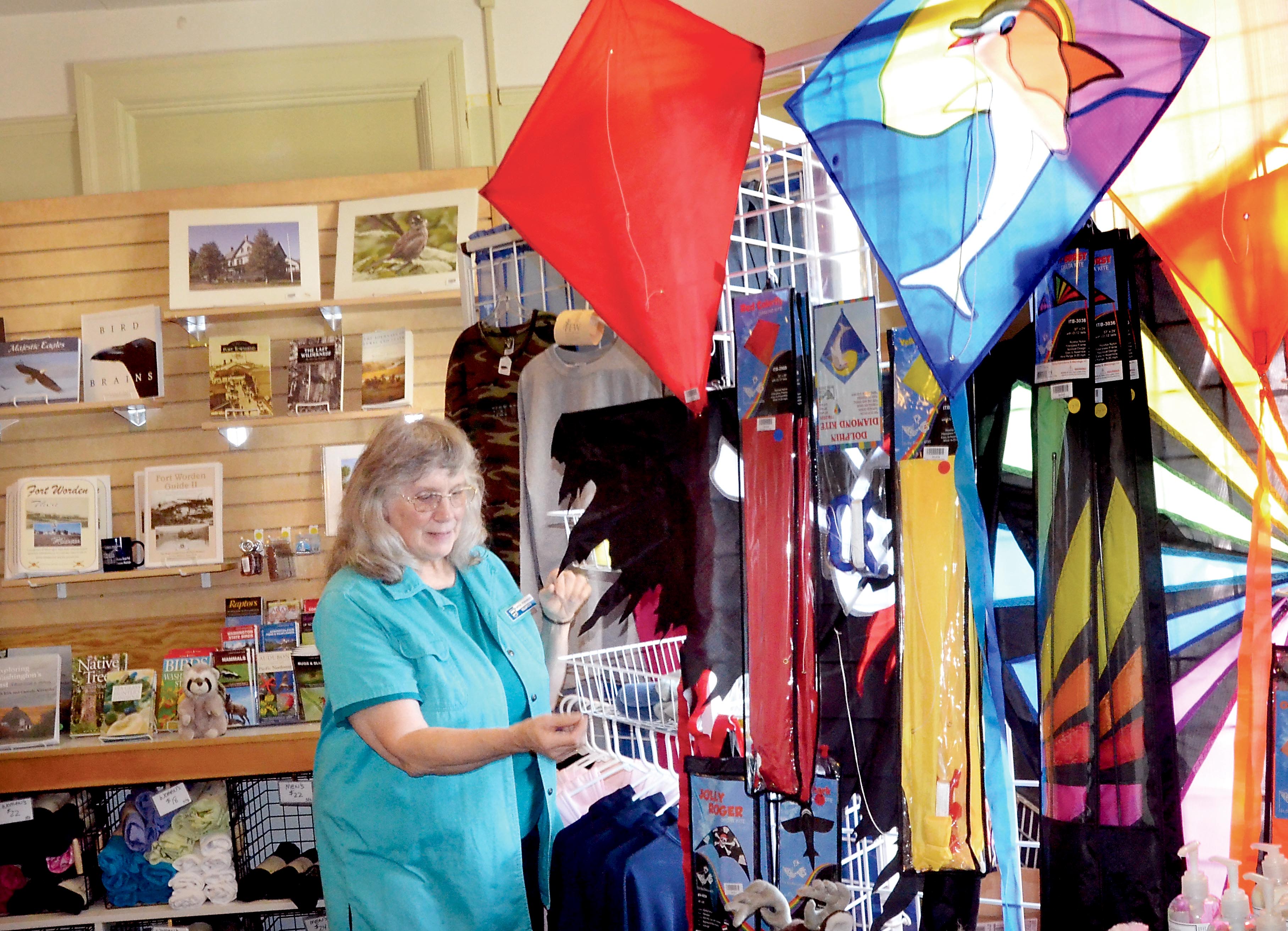 Volunteer Cathy Renskers stocks items in the newly relocated Fort Worden State Park gift shop near Port Townsend. — Charlie Bermant/Peninsula Daily News ()