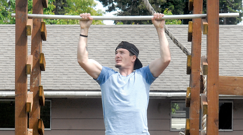 Shae Pozarzycki works out on a homemade strength-training structure behind his Port Angeles home