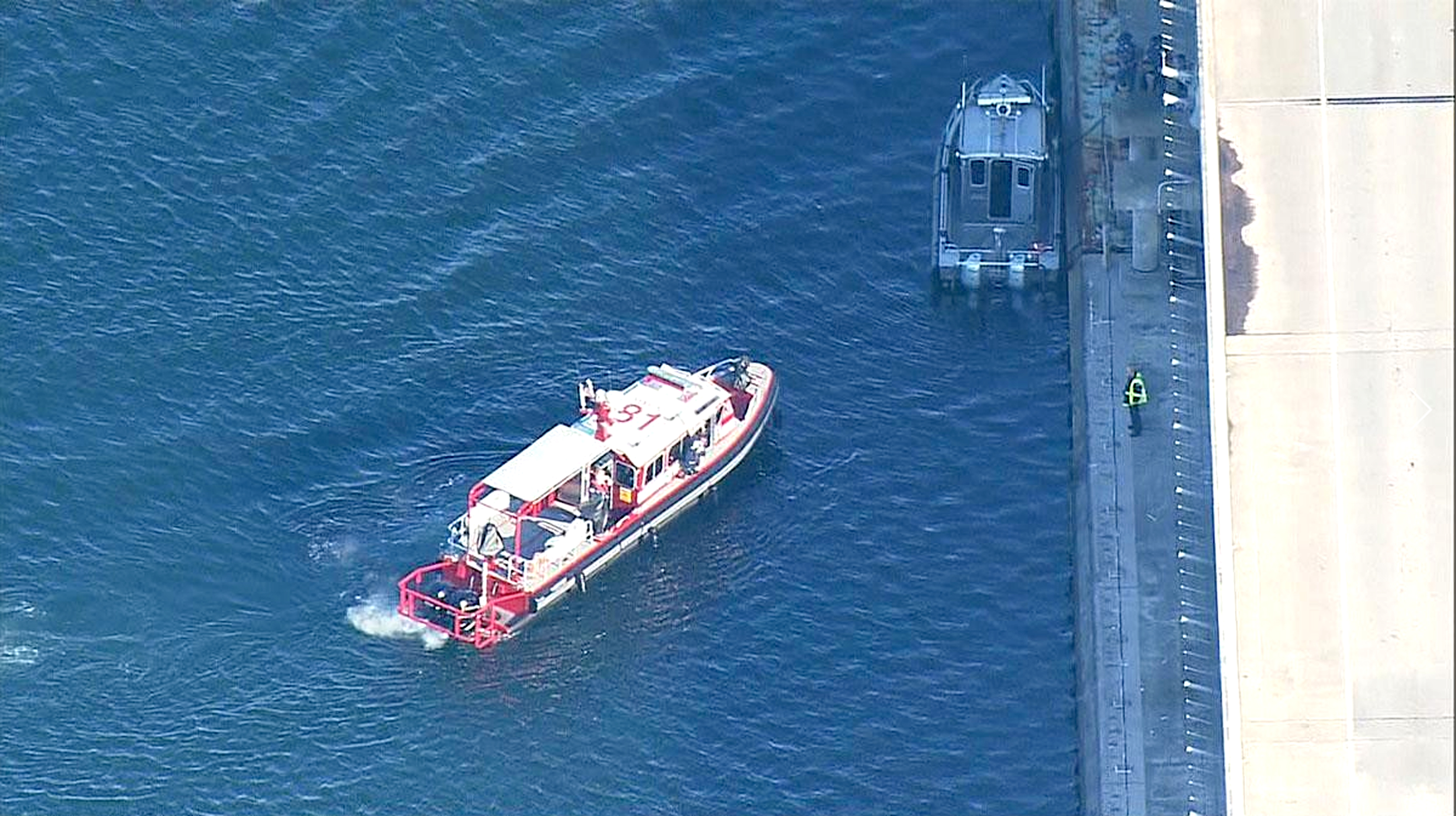 A boat from East Kitsap Fire-Rescue stands alongside the Hood Canal Bridge during search operations. — KOMO News ()