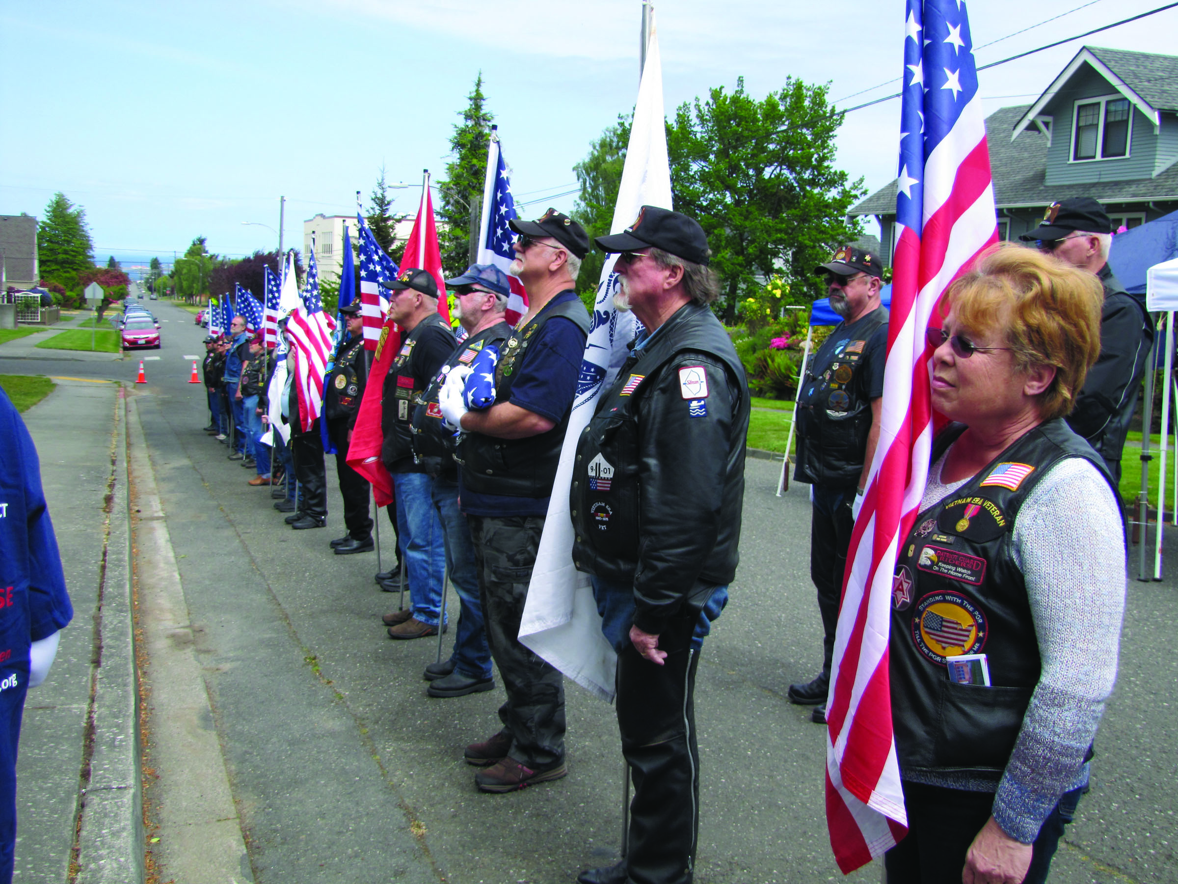 Members of American Legion Post 29 form a flag line at the Memorial Day ceremony Sunday afternoon at Captain Joseph House in Port Angeles. (Arwyn Rice/Peninsula Daily News)