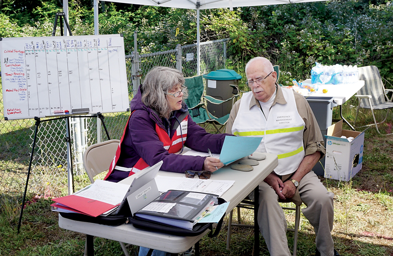 Jefferson County Public Health Nurse Julia Danskin meets Tuesday with Jefferson County Department of Emergency Management Director Bob Hamlin during the Cascadia Rising exercise. (Charlie Bermant/Peninsula Daily News)
