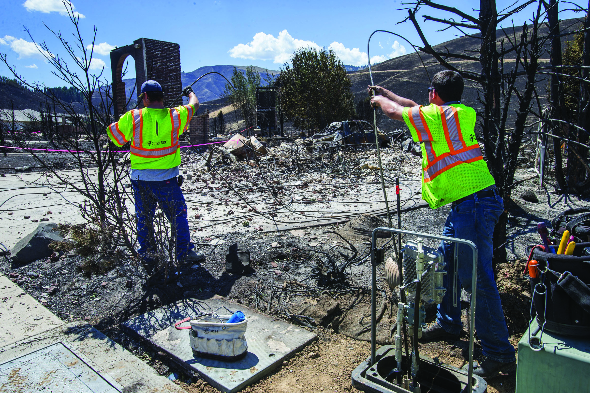 A utility crew sets out to replace the cable that was destroyed inside the Broadview neighborhood by this weekend’s fire in Wenatchee on Tuesday. The Sleepy Hollow fire in Wenatchee claimed some two dozen homes and several commercial buildings downtown. — Dean Rutz/The Seattle Times via The Associated Press