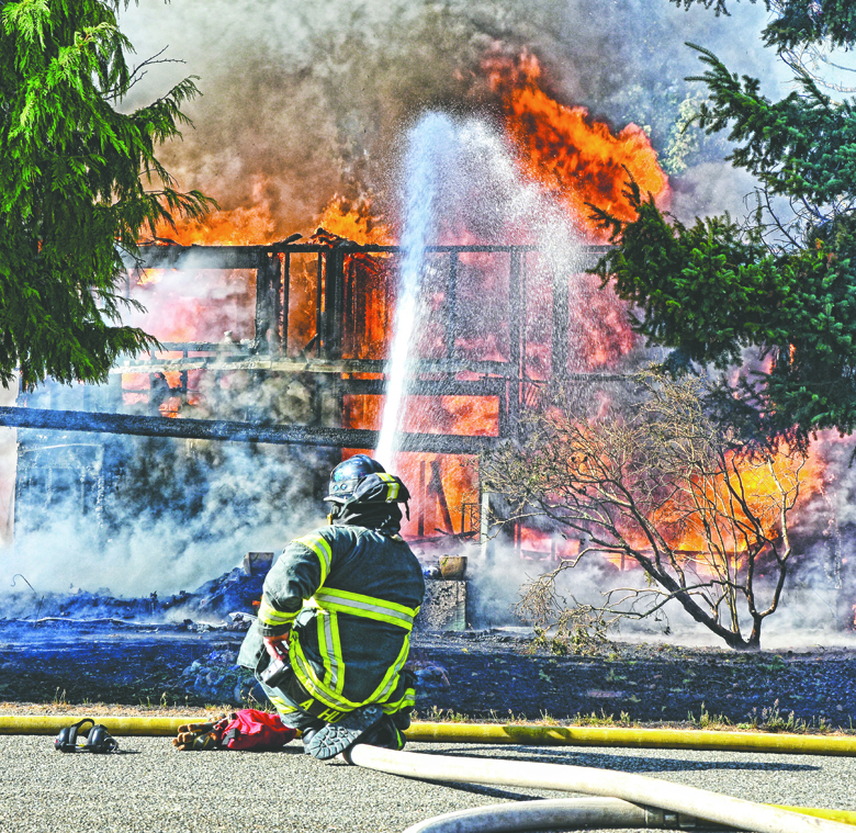 Firefighters from Clallam County Fire District No. 2 battle a blaze at 21 Whispering Firs Road off Lower Elwha Road west of Port Angeles on Thursday. Jay Cline/Clallam County Fire District No. 2