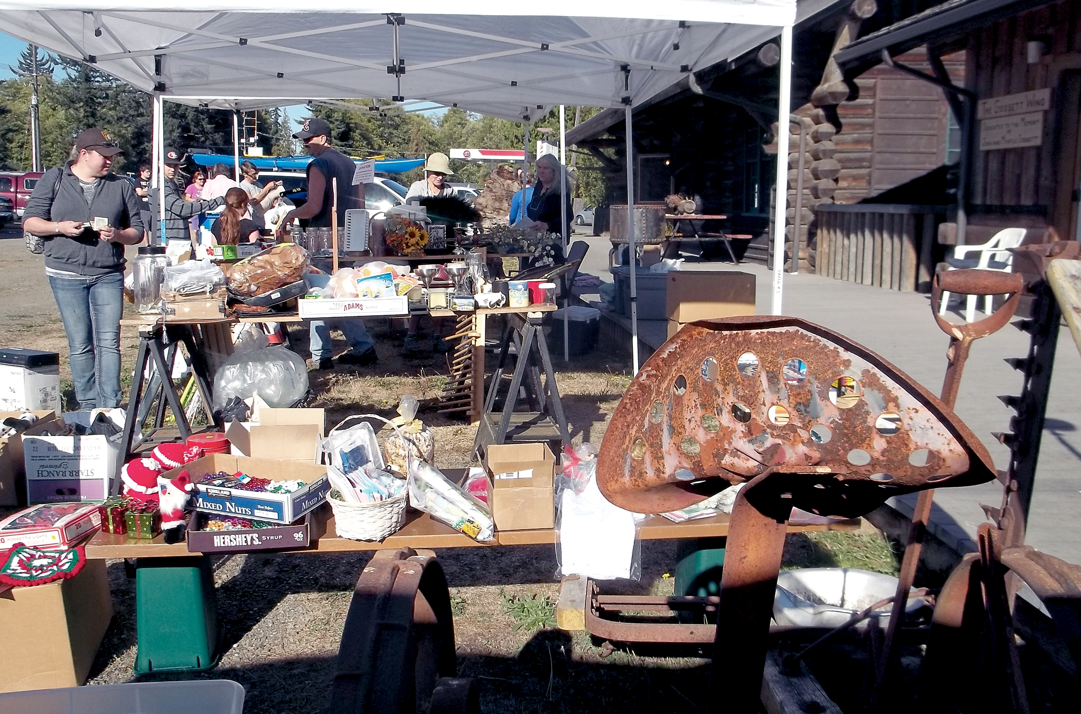 Visitors look over the goods on display at the community sale in Joyce during the 2013 Great Strait Sale. Juan de Fuca Scenic Byway Association