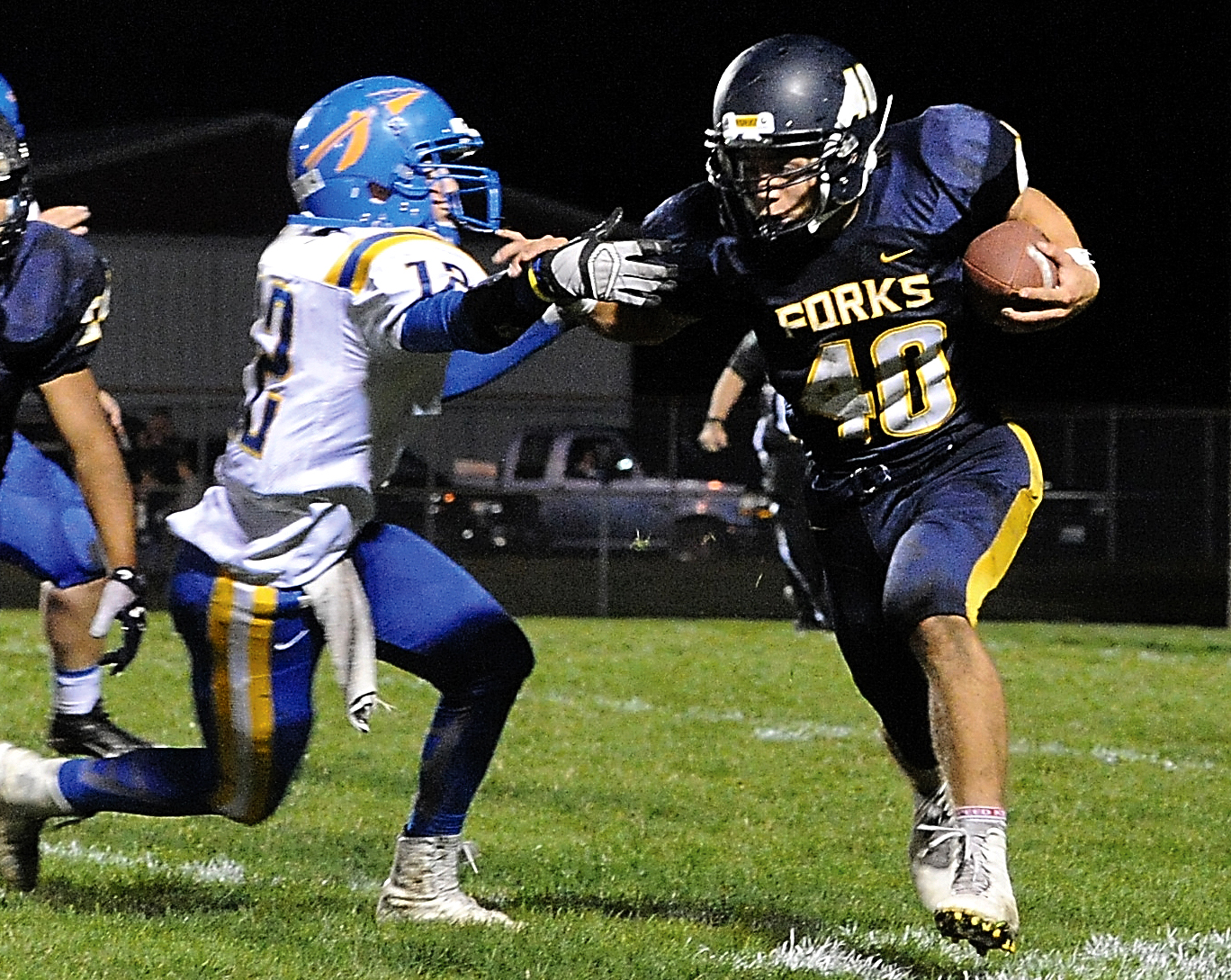 Forks running back Garrison Schumack (40) avoids the tackle of Rochester's Joumey Fortner (12). Lonnie Archibald/for Peninsula Daily News