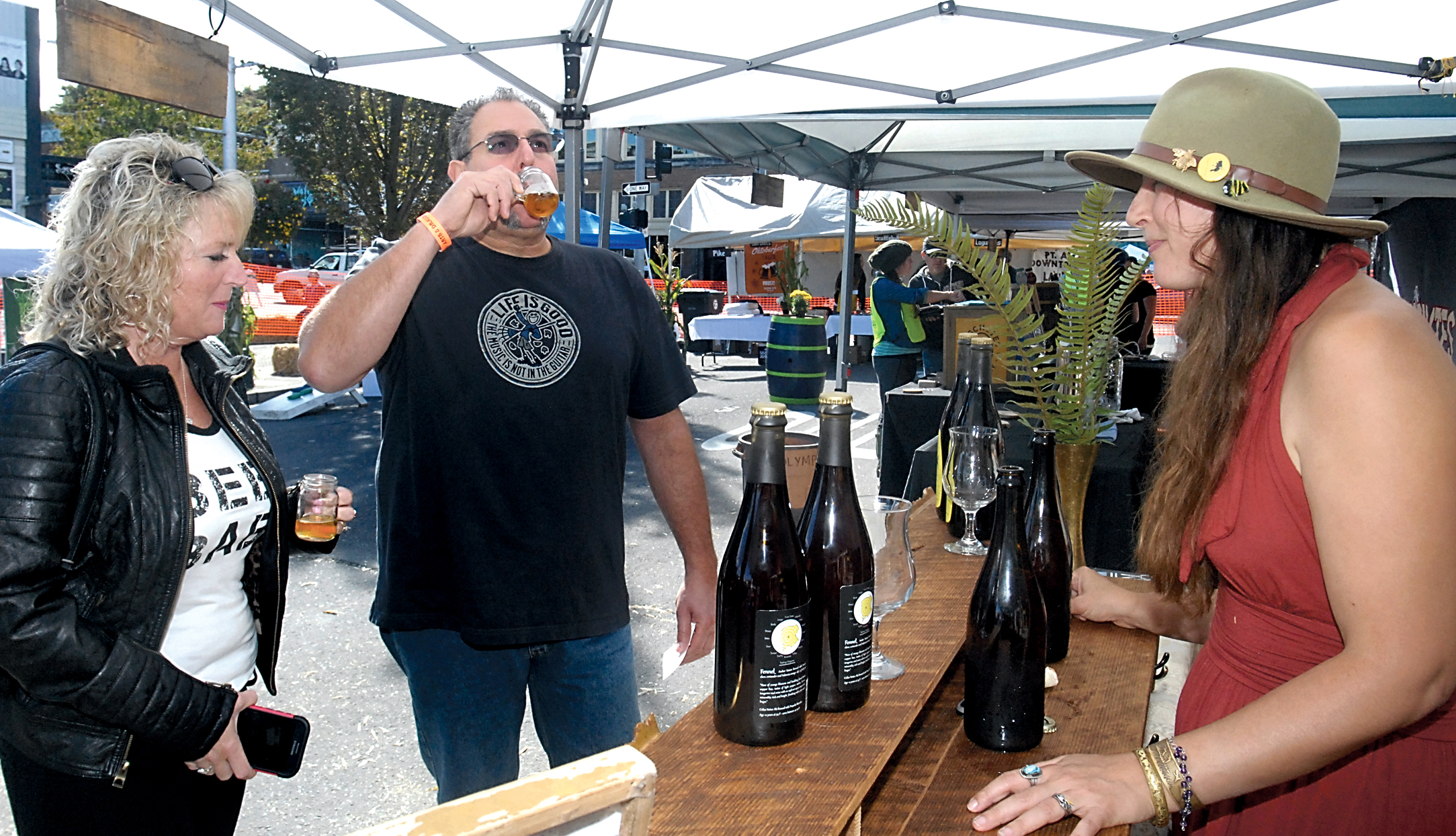 Shelly and John Barone of Port Angeles drink samples of beer served by Piper Corbett of the Port Townsend-based Propolis Brewing during the Arts & Draughts festival Saturday in Port Angeles. — Keith Thorpe/Peninsula Daily News