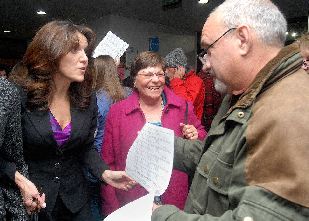Incumbent Port of Port Angeles commissioners Colleen McAleer, left, and Steve Burke, right, go over election results with friend Carol Johnson on Election Night at the Clallam County Courthouse in Port Angeles. McAleer was ahead in early returns with Burke running unopposed. Burke, who also directs the William Shore Memorial Pool in Port Angeles, also saw early approval of a levy for pool facility expansion. (Keith Thorpe/Peninsula Daily News)