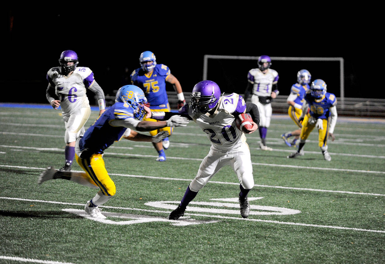 Michael Dashiell/Olympic Peninsula News Group Sequim running back Hayden Gresli, right, stiff-arms Fife’s Lavelle Alexander on his way to a big gain Friday night. Gresli had 58 yards and a touchdown in the first quarter.