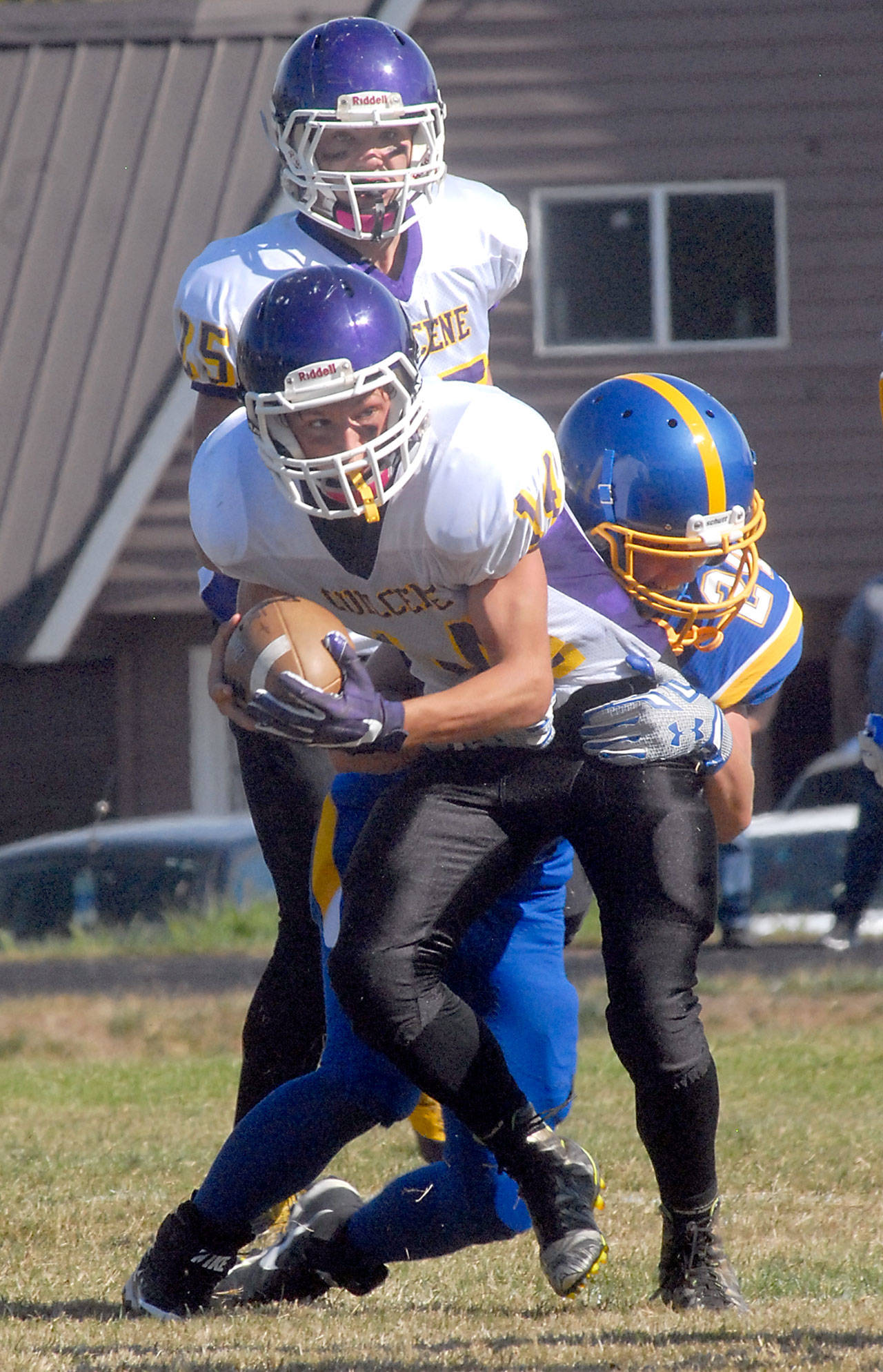 Keith Thorpe/Peninsula Daily News Quilcene’s Ben Bruner tries to elude the defense of Crescent’s Timothy Ward as his teammate, Robert Comstock III, looks on during their September matchup in Joyce.