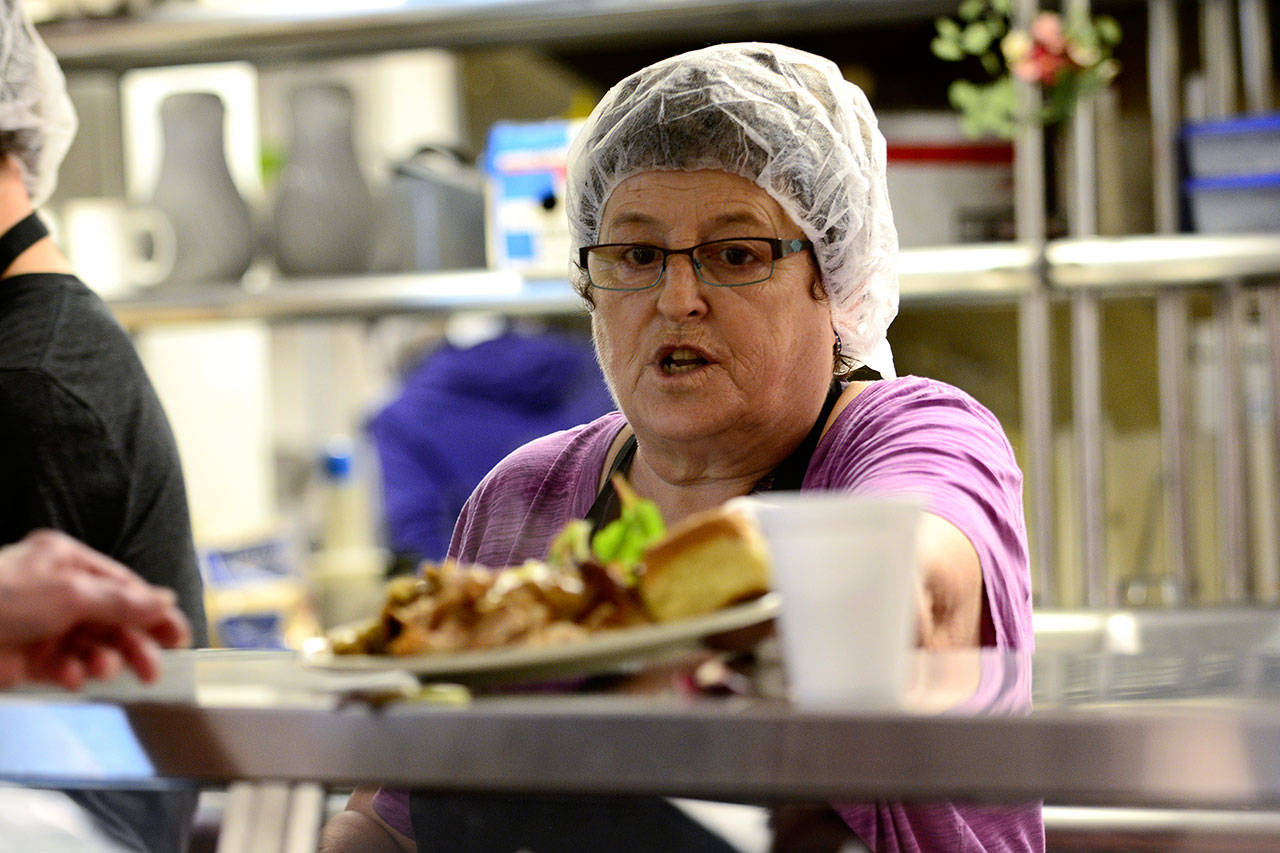 Kathy Kenyon serves up a turkey dinner during the Thanksgiving meal offered at the Salvation Army in Port Angeles on Wednesday. (Jesse Major/Peninsula Daily News)