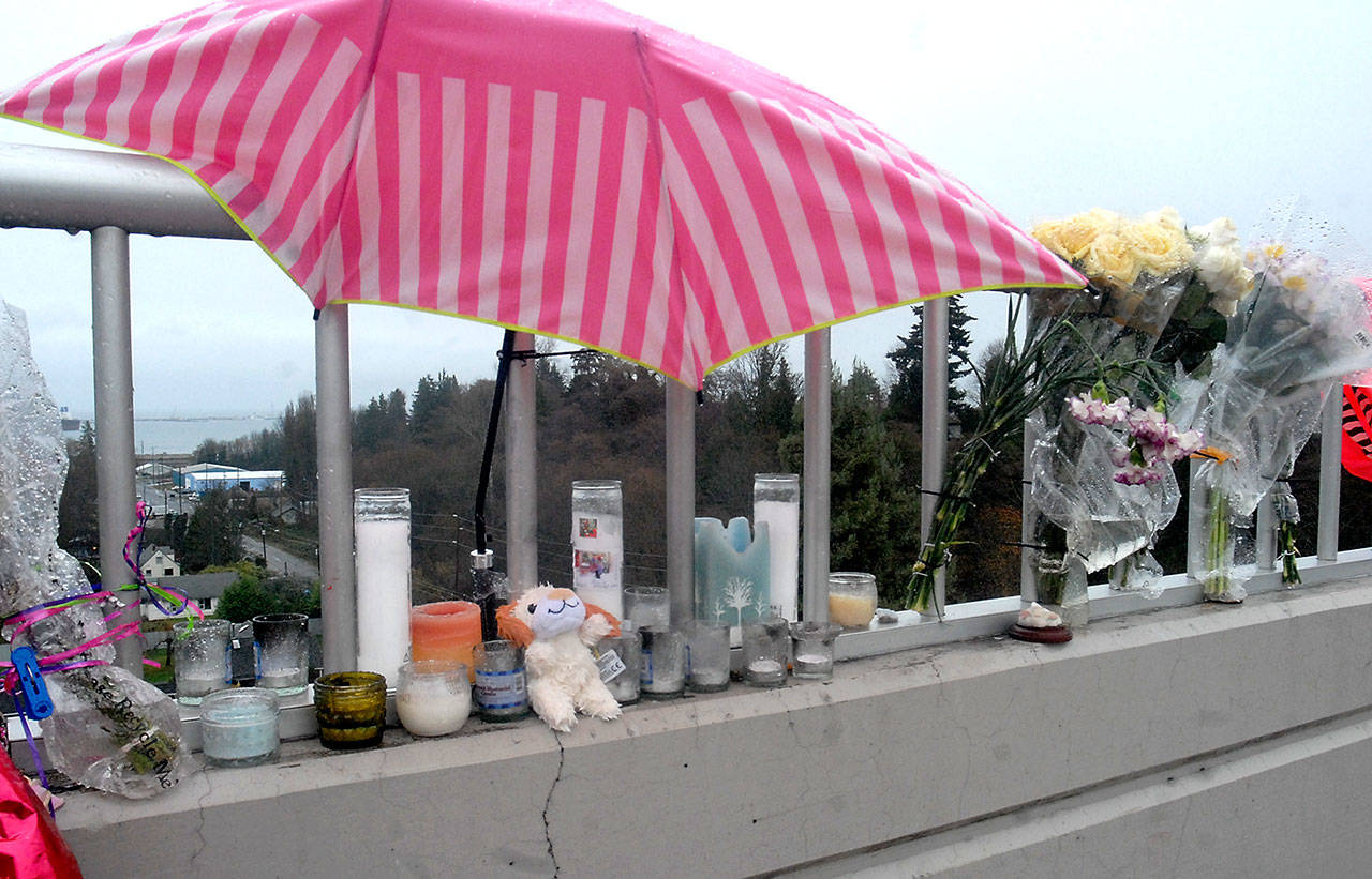 A collection of flowers, candles, dolls and an umbrella memorialize the spot where 15-year-old Ashley Wishart jumped from the Eighth Street bridge over Valley Creek on Nov. 13. (Keith Thorpe/Peninsula Daily News)
