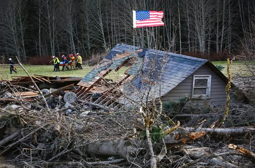 Rescue workers remove a body from the wreckage of homes destroyed by a mudslide near Oso. The Associated Press