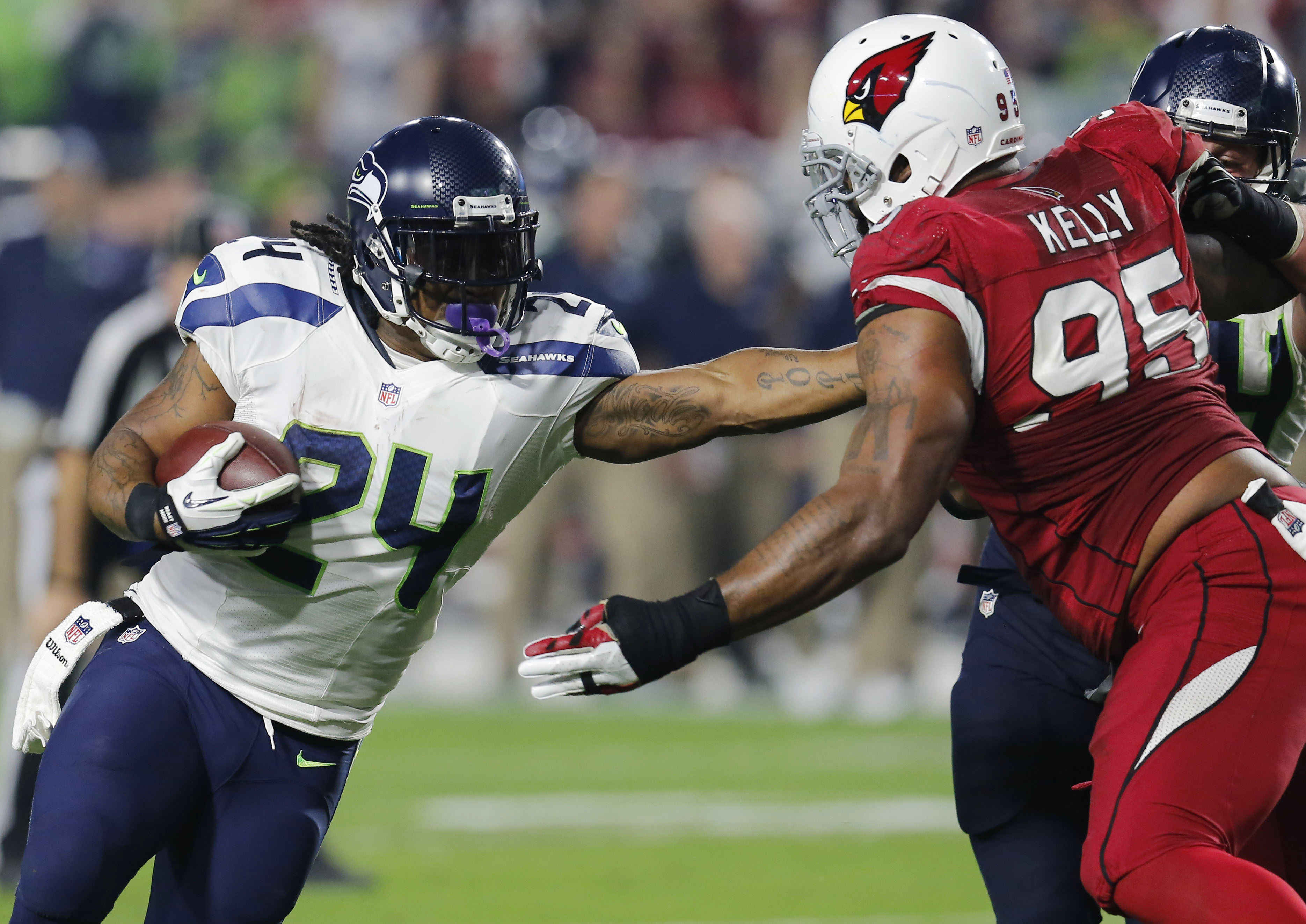 Seattle Seahawks running back Marshawn Lynch (24) fights through Arizona Cardinals defensive end Tommy Kelly (95) on his touchdown run in the first half of Seattle's 35-6 win on Sunday. The Associated Press
