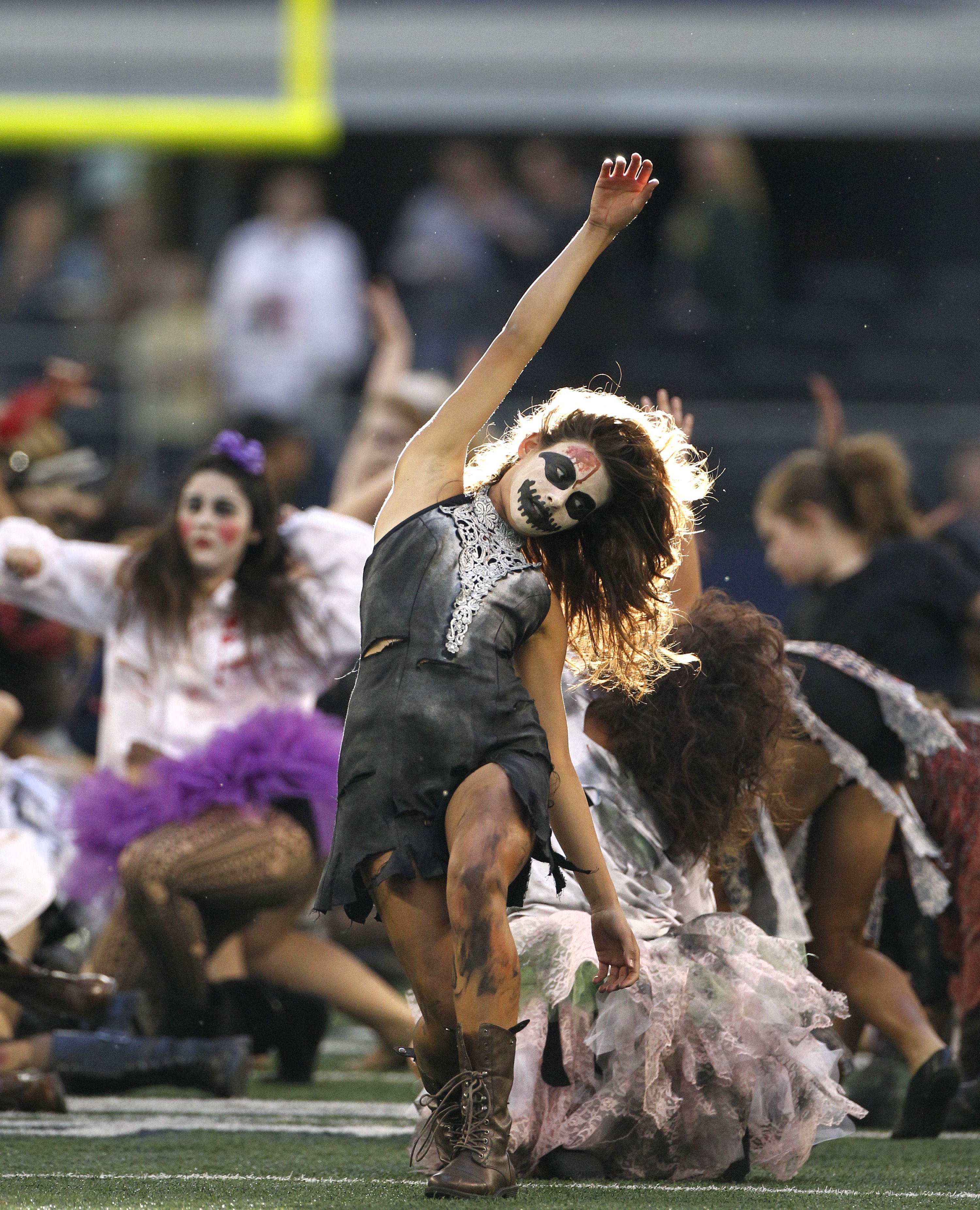 Members of the Kilgore Rangerettes dressed in Halloween zombie costumes perform along side the Dallas Cowboys cheerleaders in a halftime show during Sunday's NFL football game against the New York Giants in Arlington