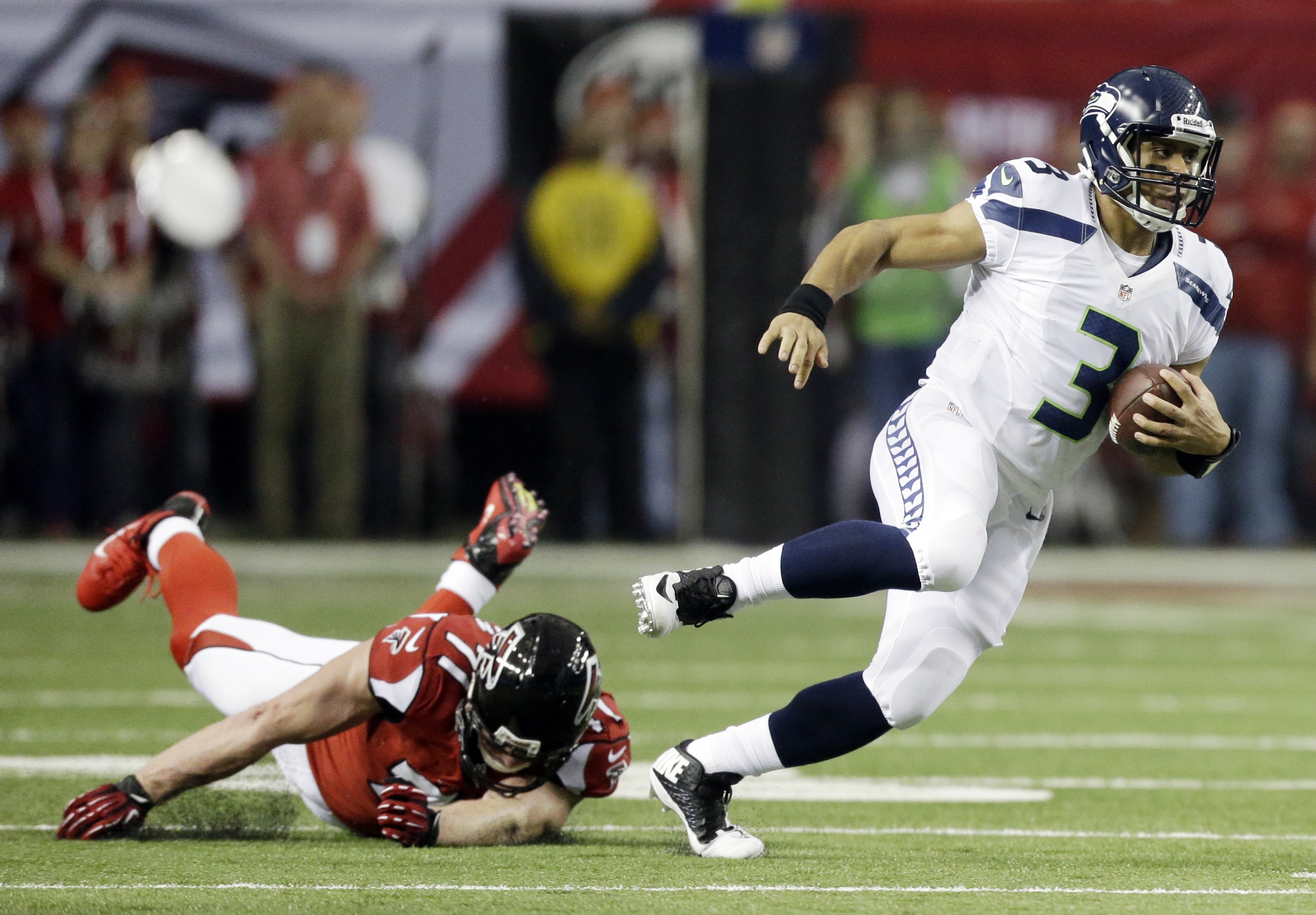 Seattle Seahawks quarterback Russell Wilson (3) runs past Atlanta Falcons defensive end Kroy Biermann (71) during the first half of Sunday's NFC divisional playoff game in Atlanta. David Goldman/The Associated Press