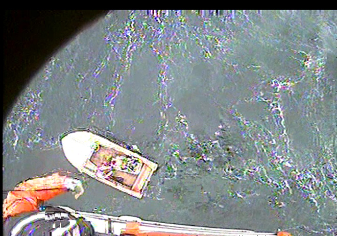 An MH-65 Dolphin helicopter crew from Air Station Port Angeles hoists a man from an 18-foot vessel off Whidbey Island on Monday. U.S. Coast Guard