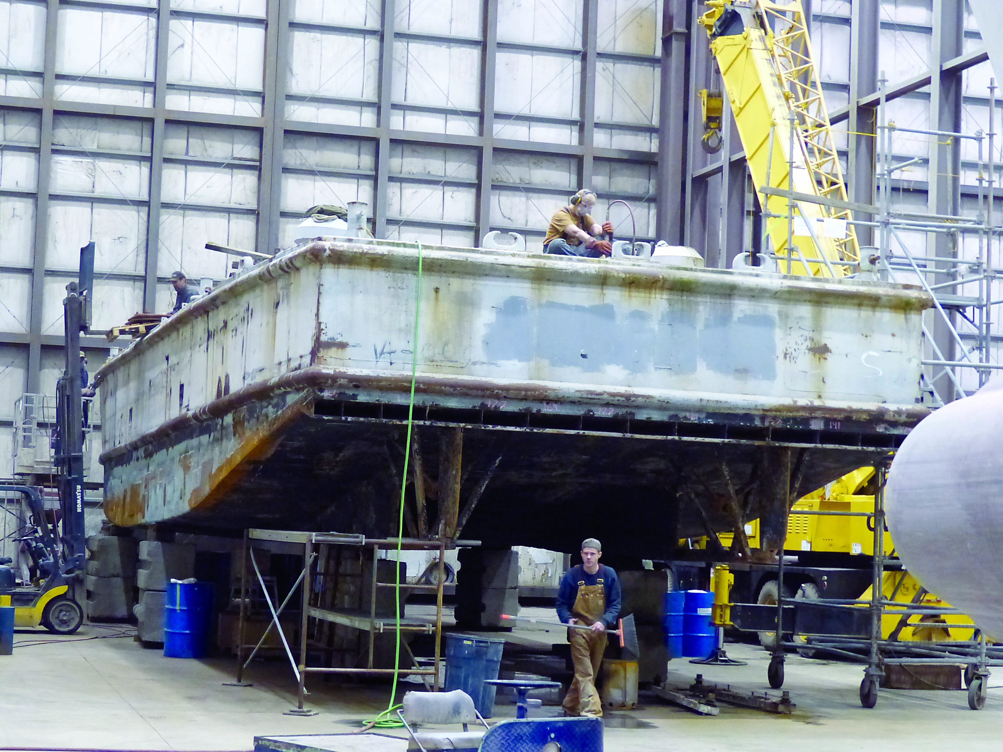 Workers at Platypus Marine Inc. in Port Angeles work on the World War II-era barge Trojan