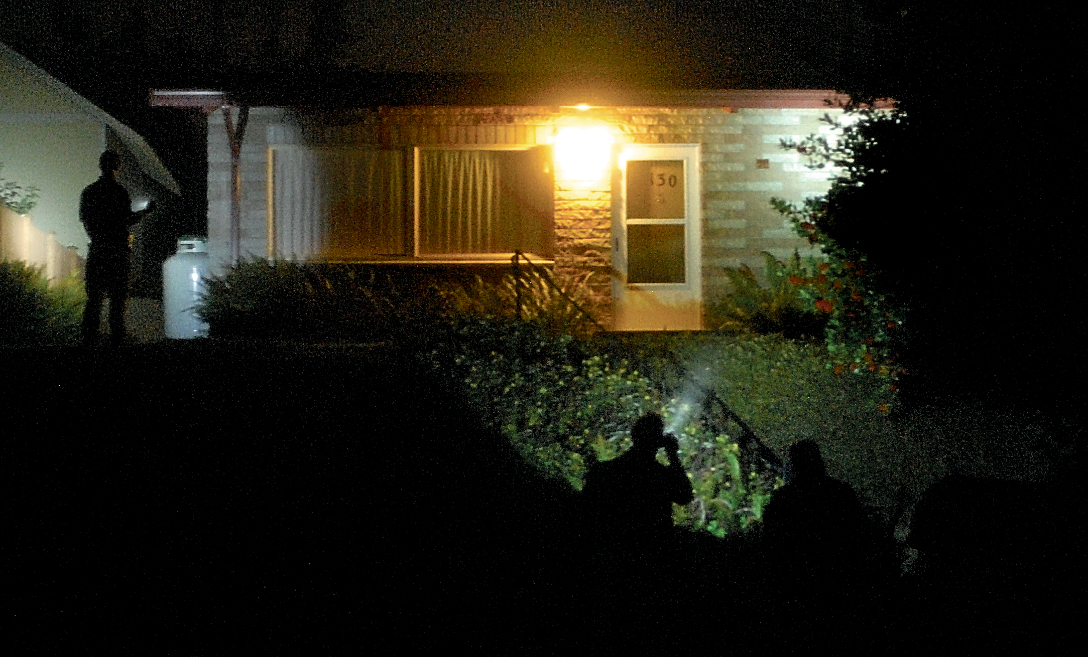 Investigators go over the scene of fatal shooting at a house in the 100 block of West 11th Street in Port Angeles. Keith Thorpe/Peninsula Daily News