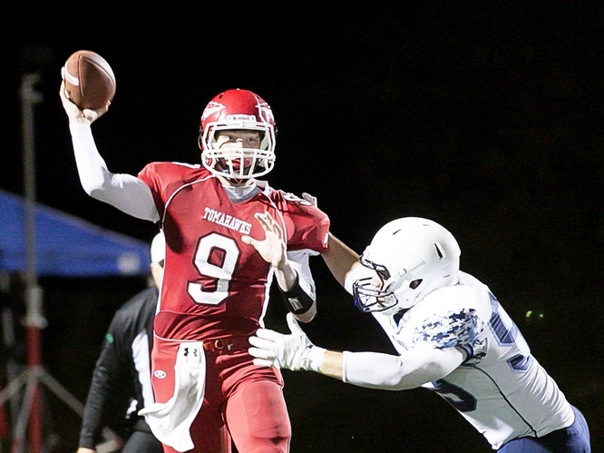 Erik Lind of Marysville Pilchuck attempts a pass as Meadowdale's Garrett Walsh goes for the sack Friday night at Quil Ceda Stadium in Marysville. The (Everett) Herald