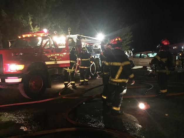 Clallam County District 2 firefighters extinguish a fire on Ennis Creek Road that started late Monday night. Chief Sam Phillips/Clallam County Fire District 2