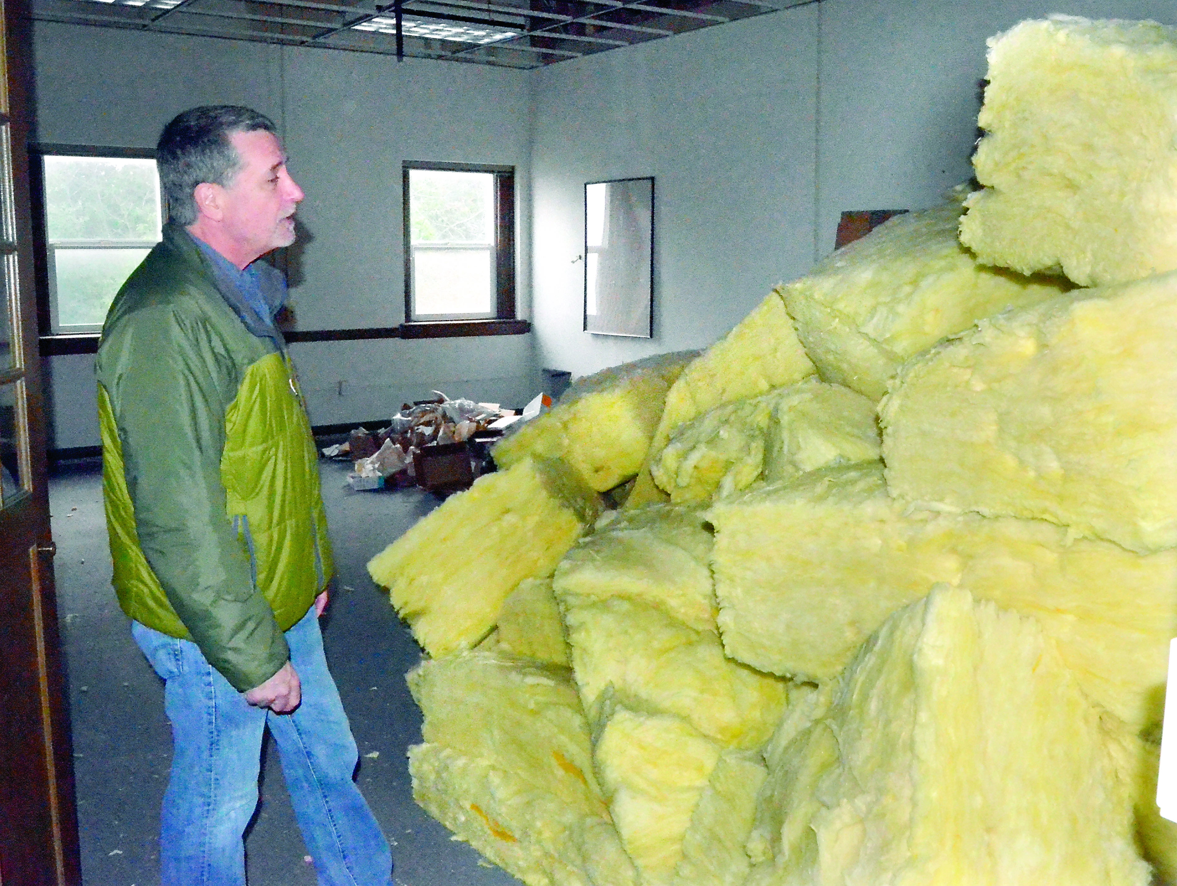Port Townsend School District Director of Support Services Brad Taylor inspects some of the insulation stored in the condemned Lincoln Building. — Charlie Bermant/Peninsula Daily News