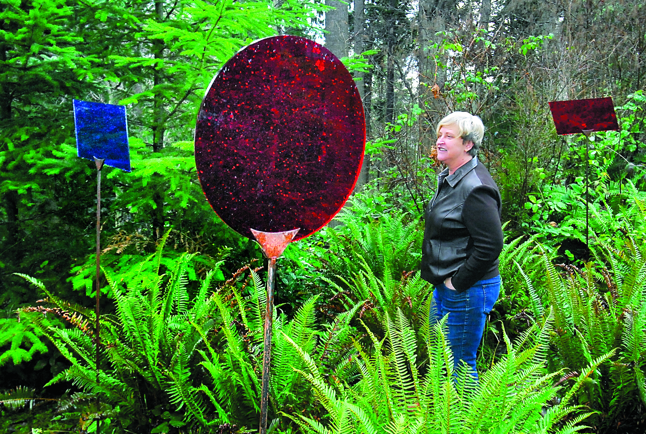 Port Angeles Fine Arts Center executive director Robin Anderson walks through a portion of the restored art installation "Linger" by Seattle artist Carolyn Law in the Webster's Woods outdoor art park on Thursday. Keith Thorpe/Peninsula Daily News