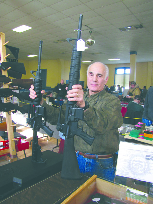Port Angeles gun dealer Nicholas De Scala holds an A-15 assault-style rifle