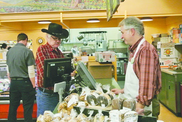 Food Co-op customer Curt Sicklovan purchases his lunch from Seth Hager on Monday. Co-op management made a presentation to the Jefferson County Chamber of Commerce on Monday. Charlie Bermant/Peninsula Daily News