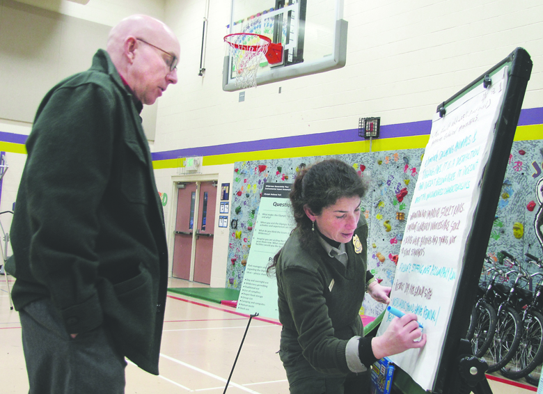Tom Bihn of Port Angeles suggests an addition to a list to U.S. Park Ranger Sanny Lustig during Olympic National Park's “scoping meeting” Tuesday at Jefferson Elementary School in Port Angeles. Bihn said he wanted to see more cohesive wilderness management in the park. Arwyn Rice/Peninsula Daily News