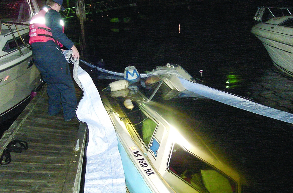 Workers mop up a spill of gasoline from a sunken boat at Gig Harbor on Tuesday night. State Department of Ecology