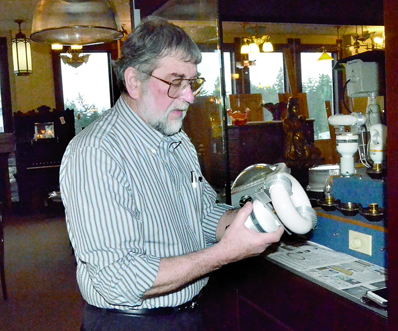 Vintage Hardware owner Ken Kelly holds an induction bulb. Kelly will give a presentation about different lighting technologies at the Home and Garden Expo on Saturday. Charlie Bermant/Peninsula Daily News