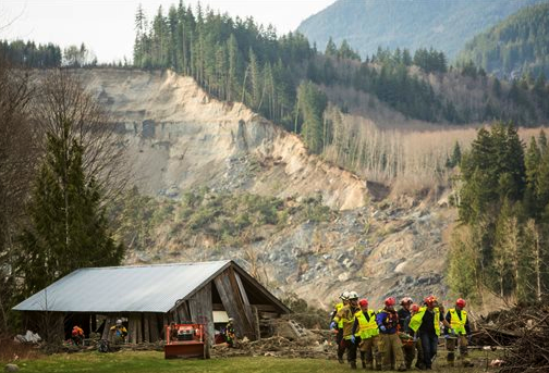 Rescue workers remove one of a number of bodies from the wreckage of homes destroyed by a mudslide near Oso. The Associated Press