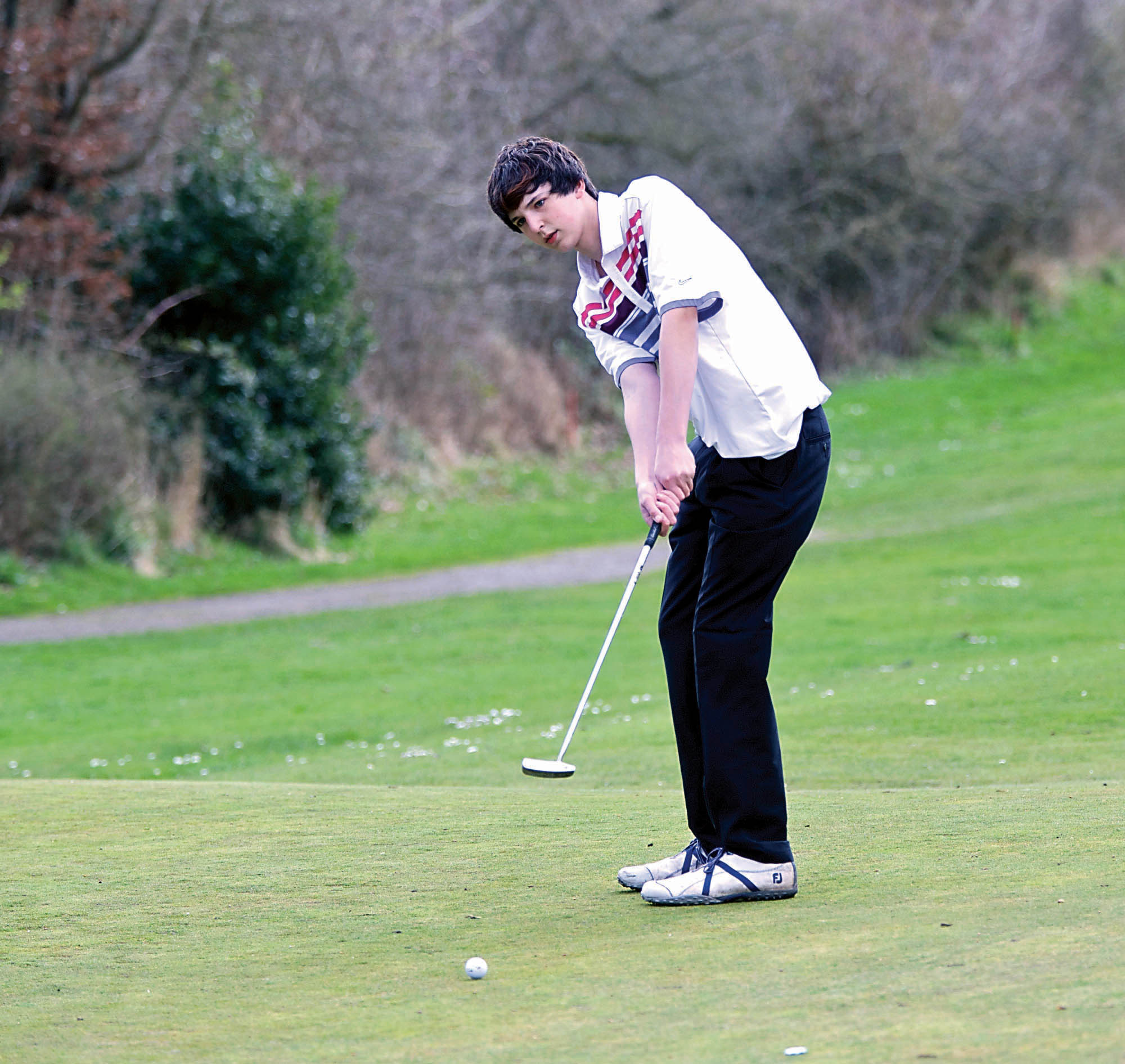 Port Townsend's Patrick Morton rolls a putt in for a birdie on the first hole Tuesday against Port Angeles at Port Townsend Golf Course. Steve Mullensky/for Peninsula Daily News