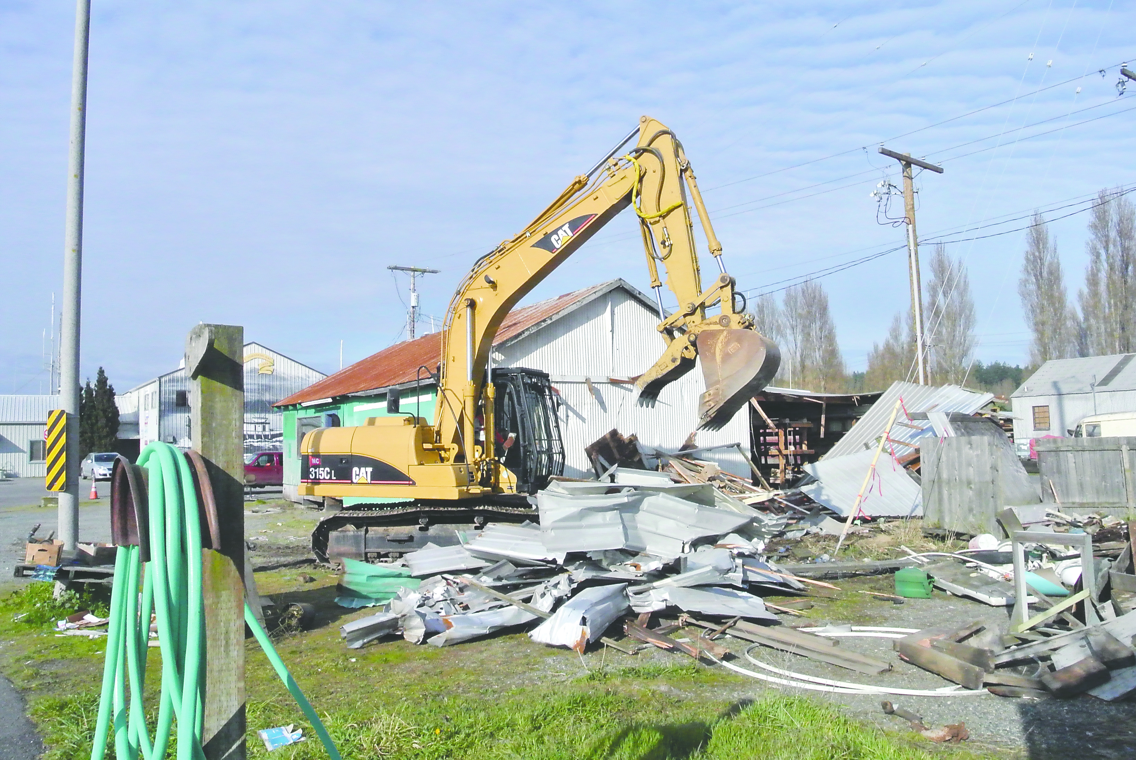 Heavy equipment is used to separate the metal from the wood during the demolition project for the site where the new Port of Port Townsend administration building will be constructed. Charlie Bermant/Peninsula Daily News