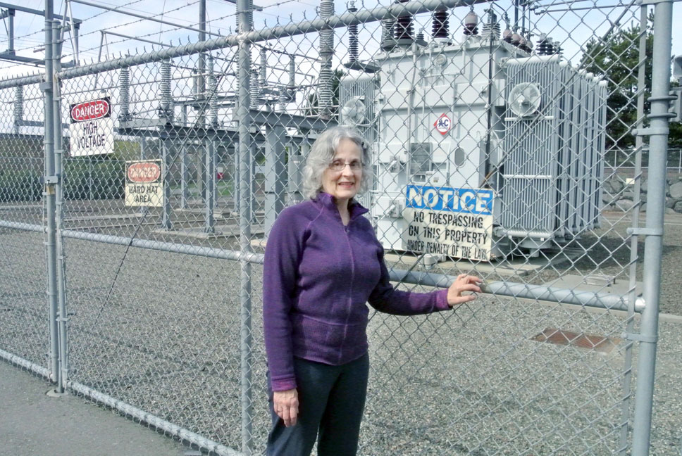 Carol Anne Modena stands in front of the Kearney Street substation in Port Townsend