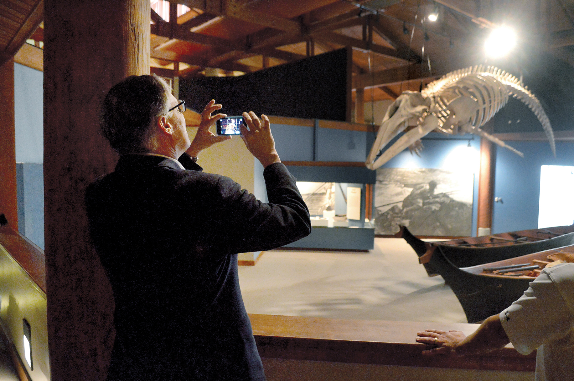 Gov. Jay Inslee snaps a photo of the skeleton of a gray whale hunted by Makah whalers in 1999 during a visit to the Makah Museum on Friday. — Photo by Joe Smillie/Peninsula Daily News