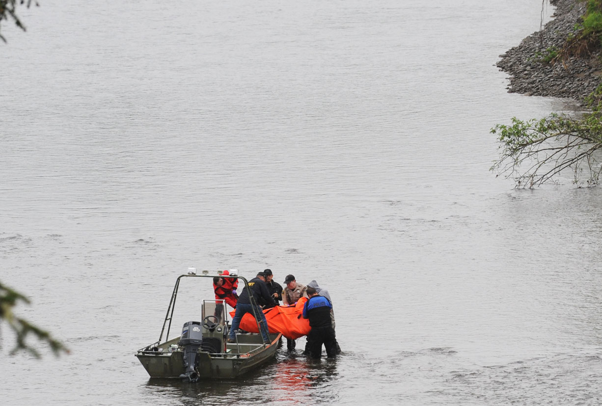 The body discovered Saturday afternoon is taken to a jet boat by authorities on the Bogachiel River near Leyndecker Park east of LaPush. Lonnie Archibald/for Peninsula Daily News
