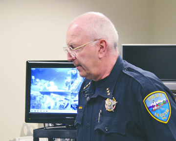 Sequim Police Chief Bill Dickinson stands with a TV monitor showing surveillance video taken at a tavern Saturday night. Joe Smillie/Peninsula Daily News